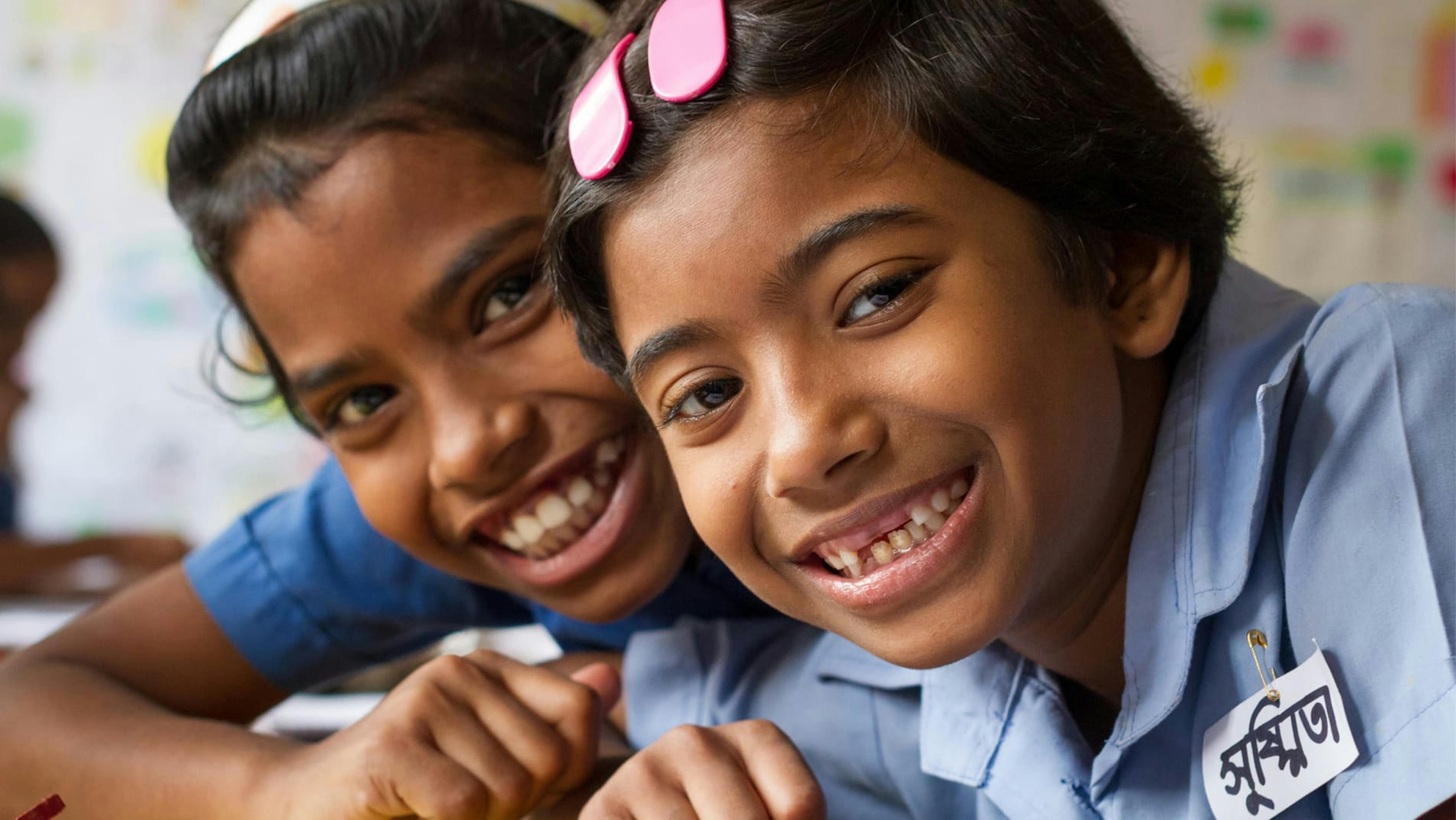 Shushmita e la sua amica Binky sorridono mentre sono a scuola, in Bangladesh.