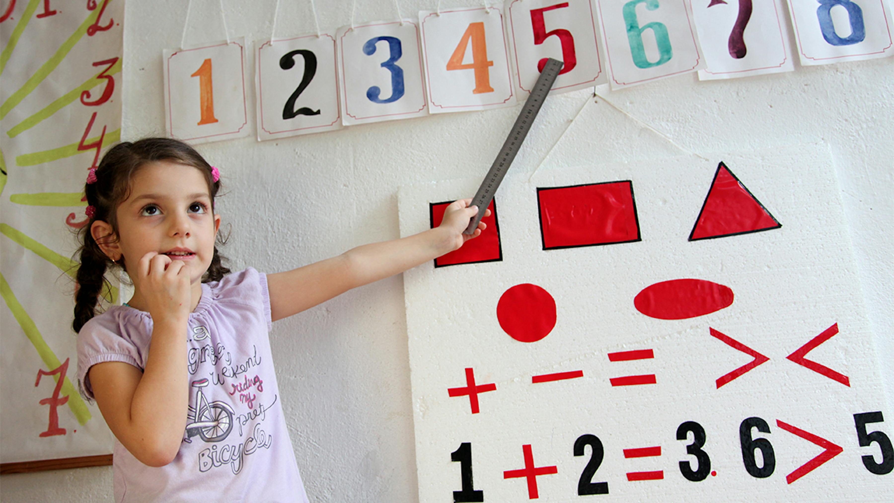 Azerbaijan, Una bambina impara a identificare i numeri nel suo primo giorno di scuola.