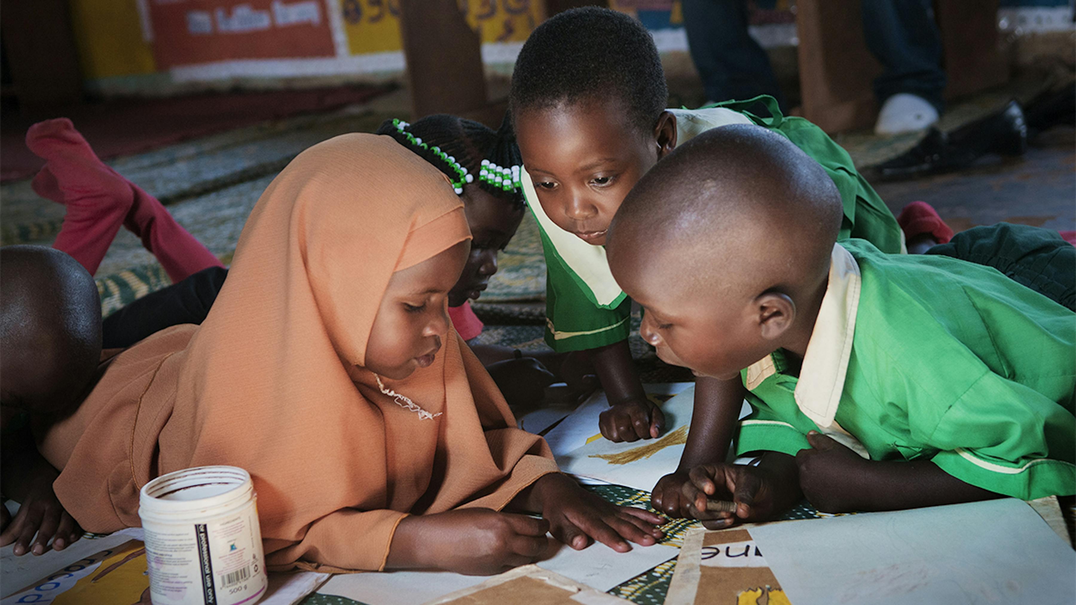 Uganda, due bambini disegnano in una scuola materna.
