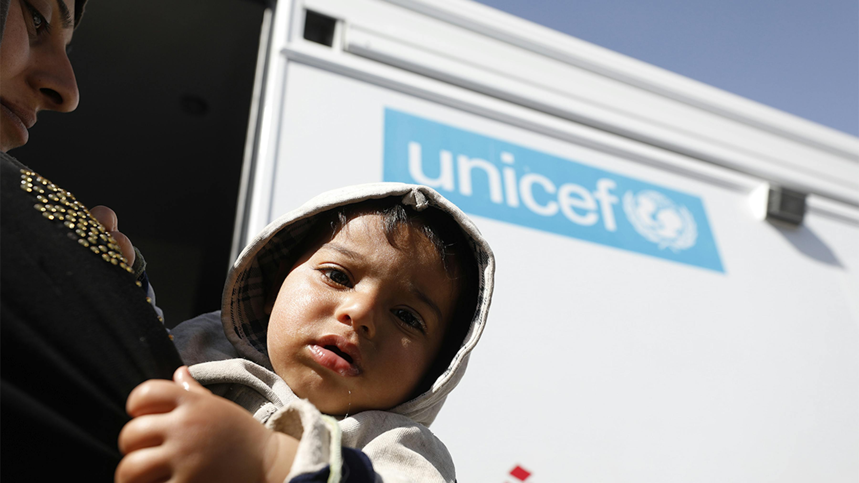 Siria,un bambino e sua madre entrano nella clinica sanitaria mobile supportata dall'UNICEF