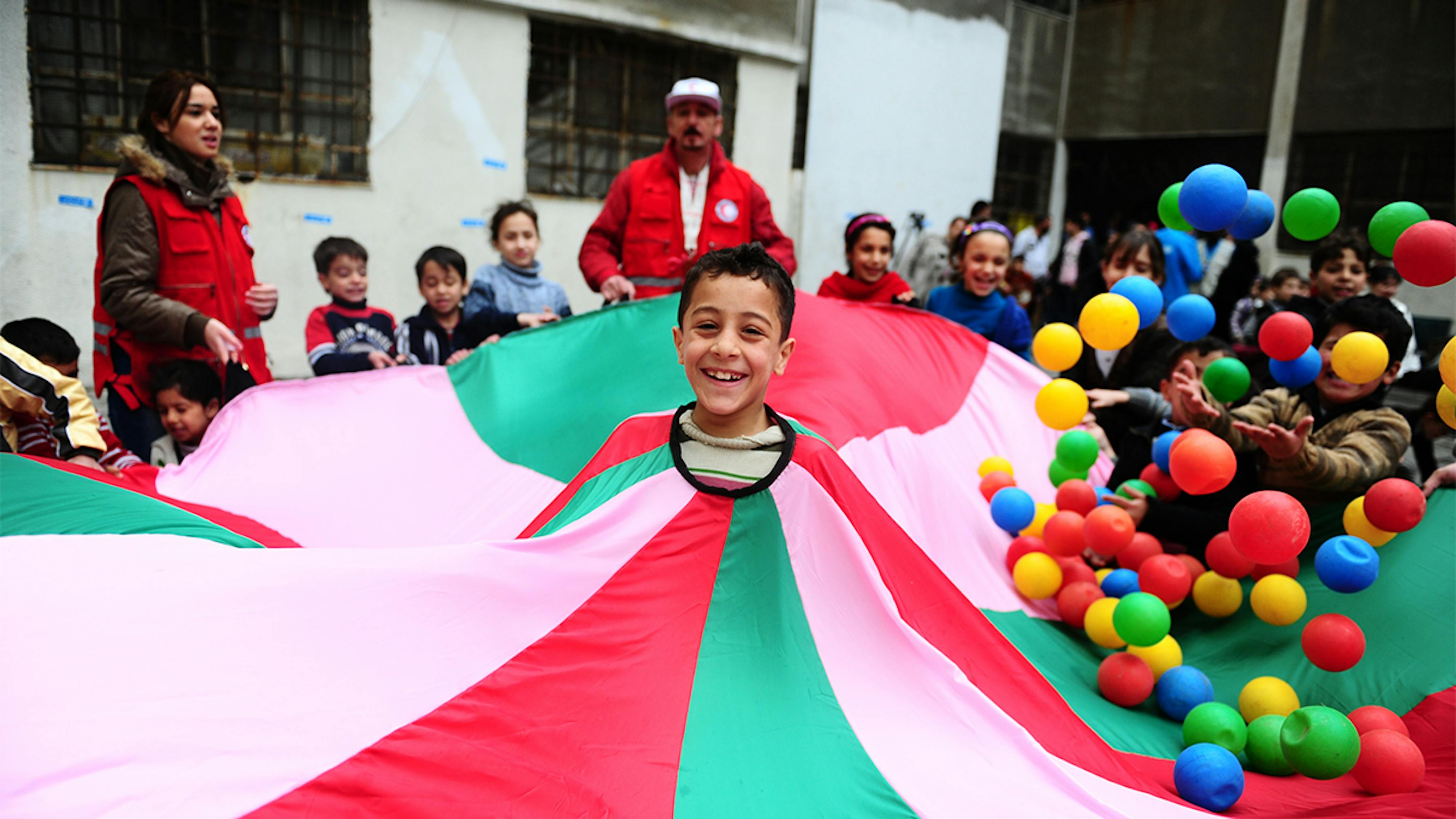 Siria, bambini sorridono durante un'attività ricreativa in un rifugio per famiglie sfollate a Homs