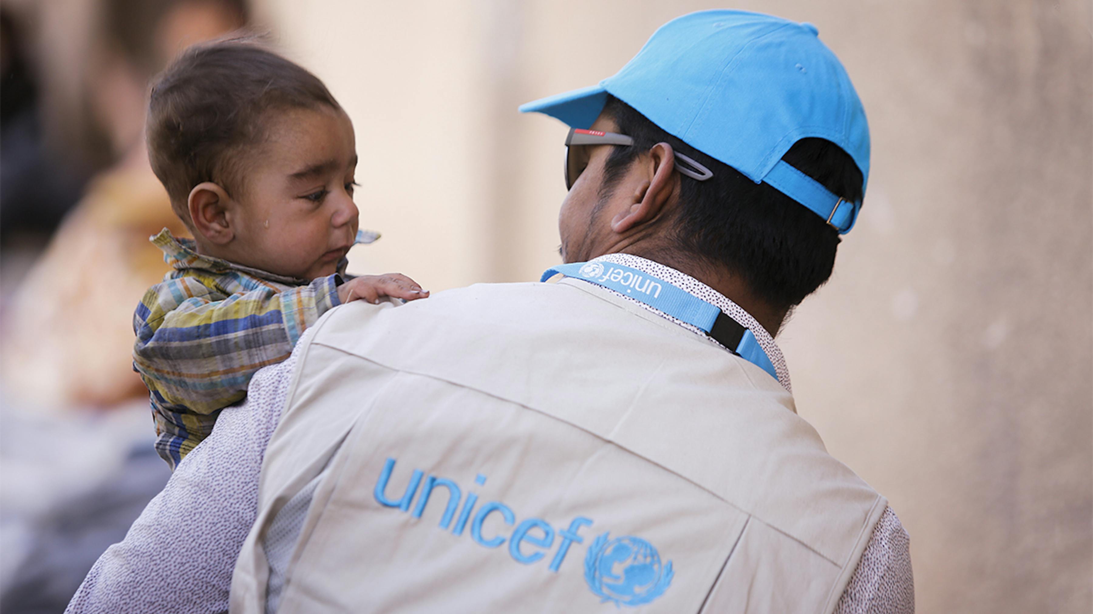 Siria, un bambino con un operatore dell'UNICEF