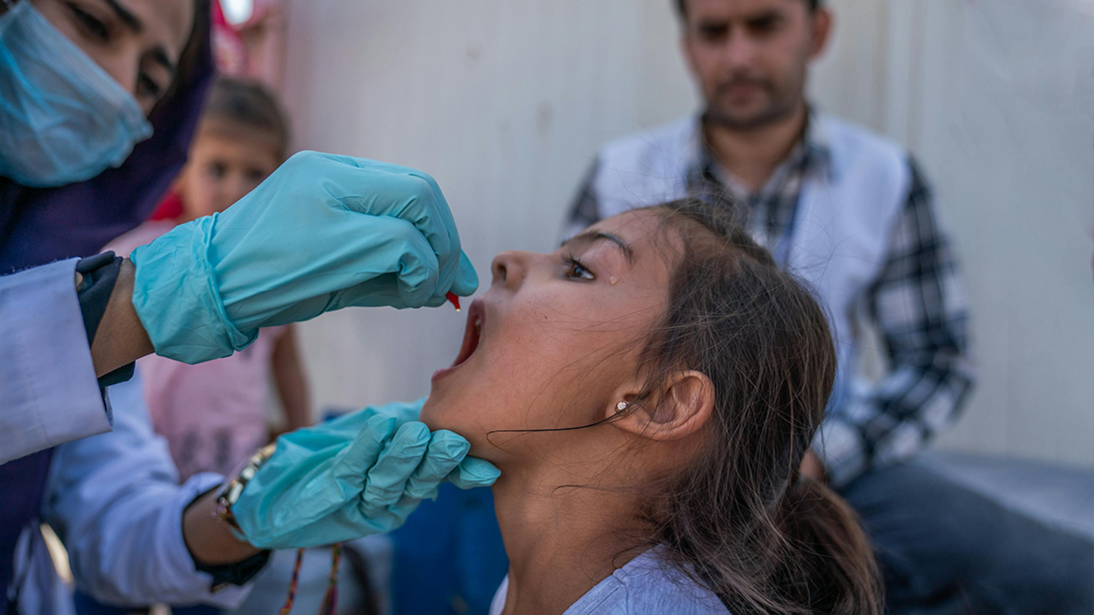 Iraq, una bambina rifugiata siriana viene vaccinata contro la polio