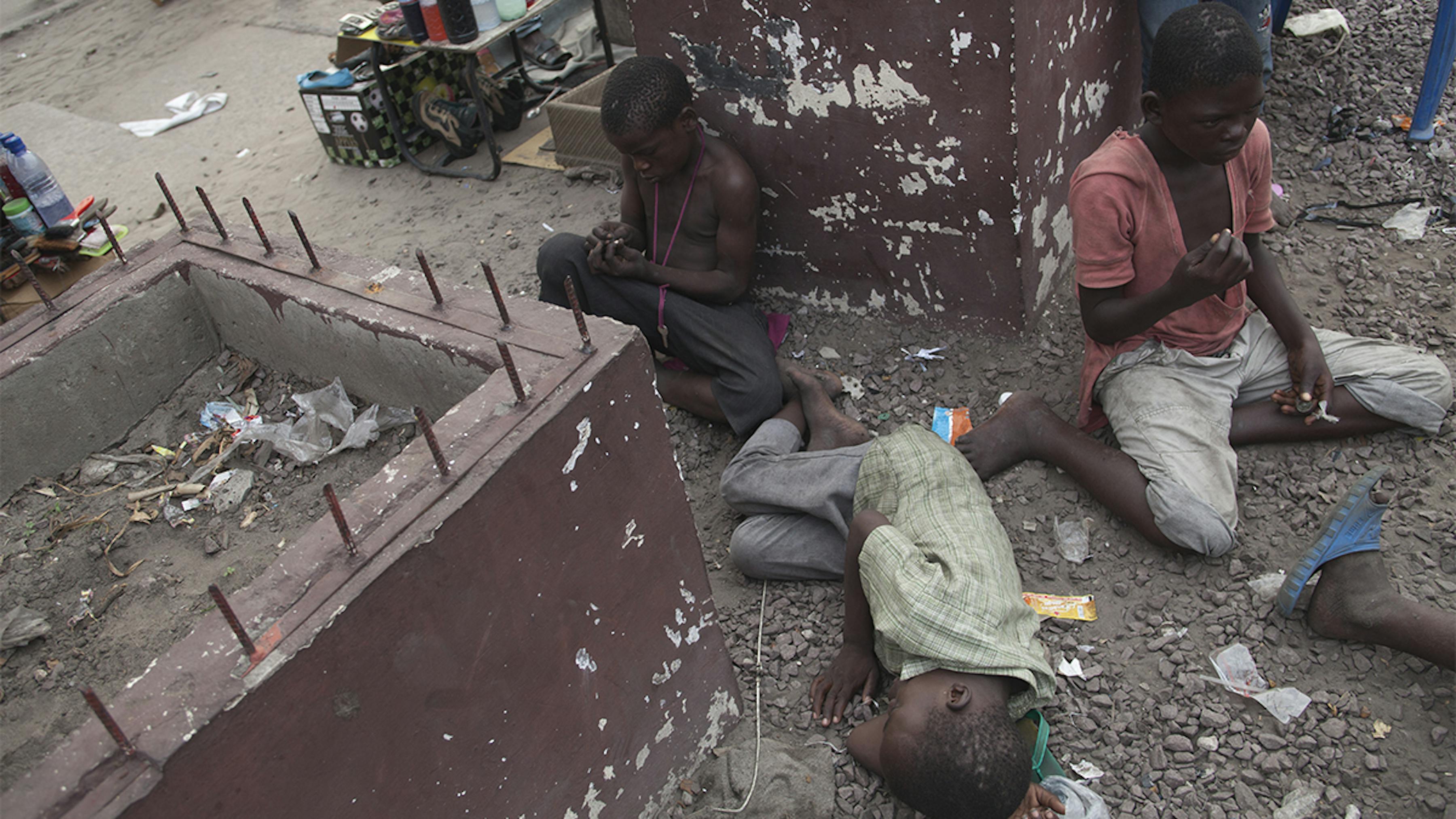 Congo, alcuni bambini di strada seduti o sdraiati a riposare.