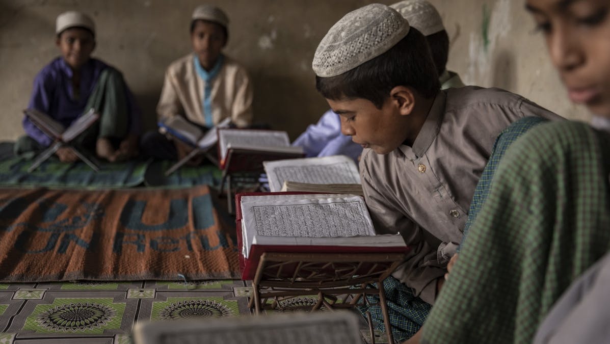 Bangladesh, un ragazzo legge dal suo libro di testo in una madrasa nel campo di Kutupalong-Balukhali, Cox's Bazar