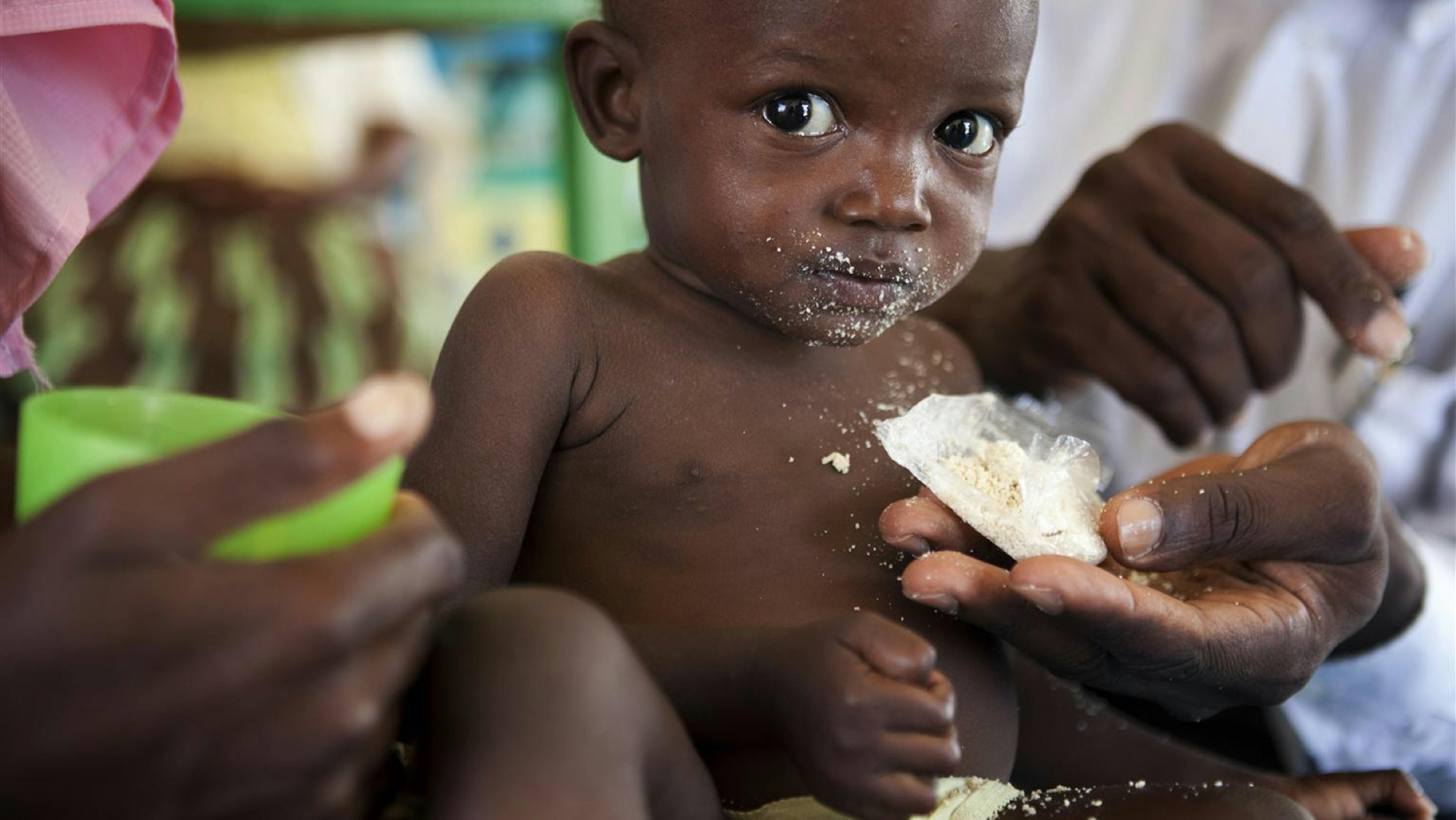 Bambino malnutrito mangia un biscotto energetico 