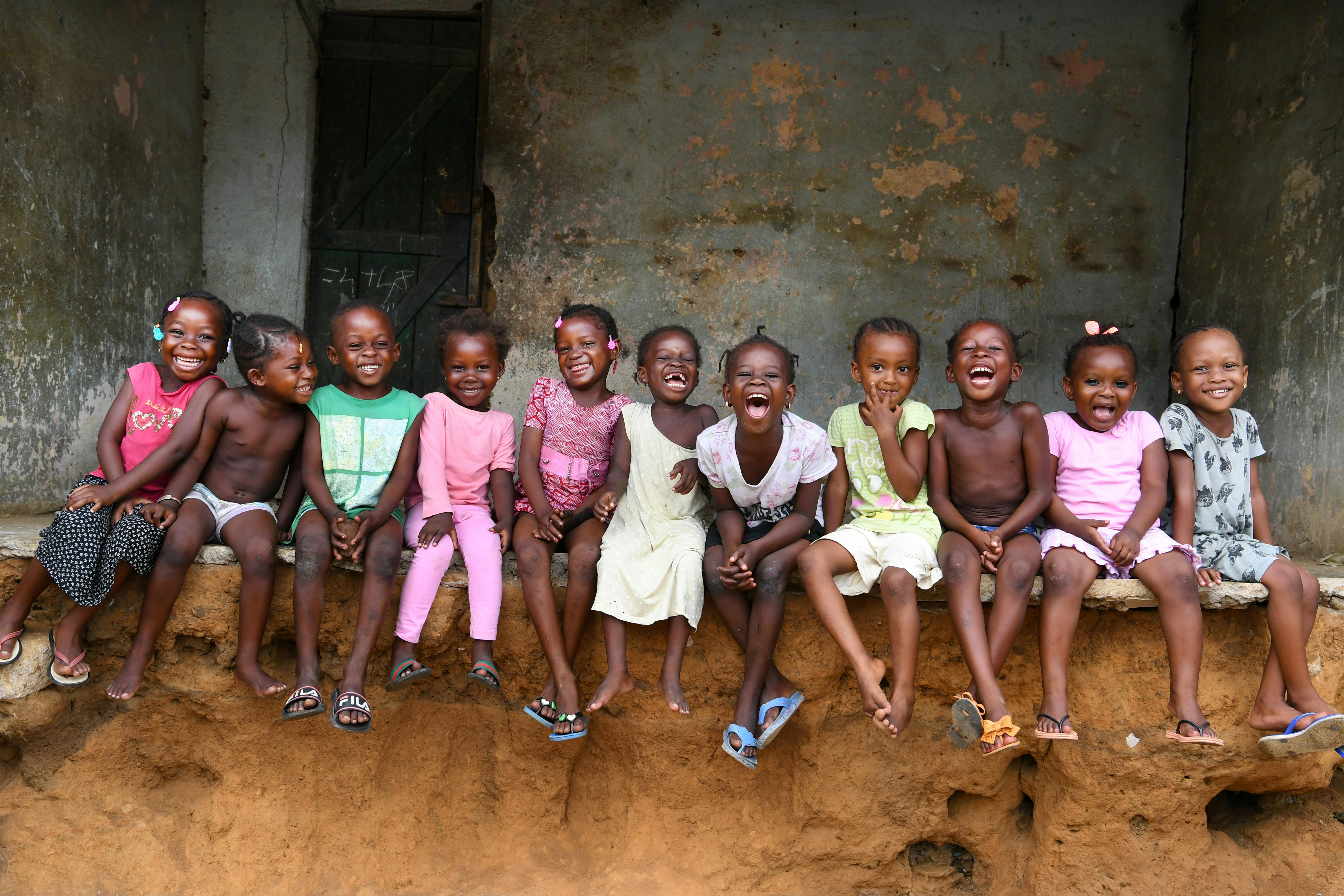 Bambine e bambini della Costa D'Avorio sorridono davanti all'obiettivo.
