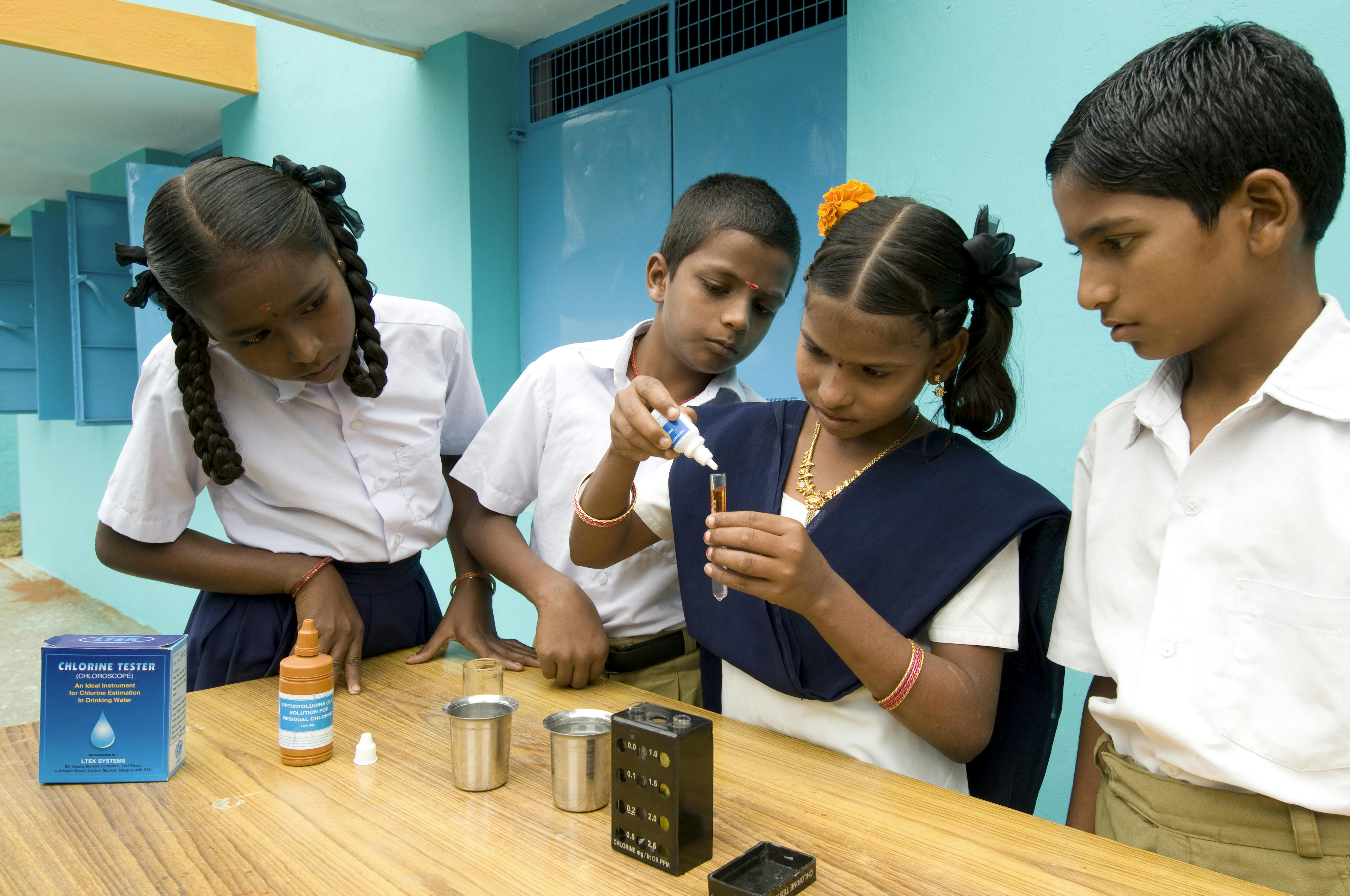 Bambini eseguono un test con il cloro in una scuola in India