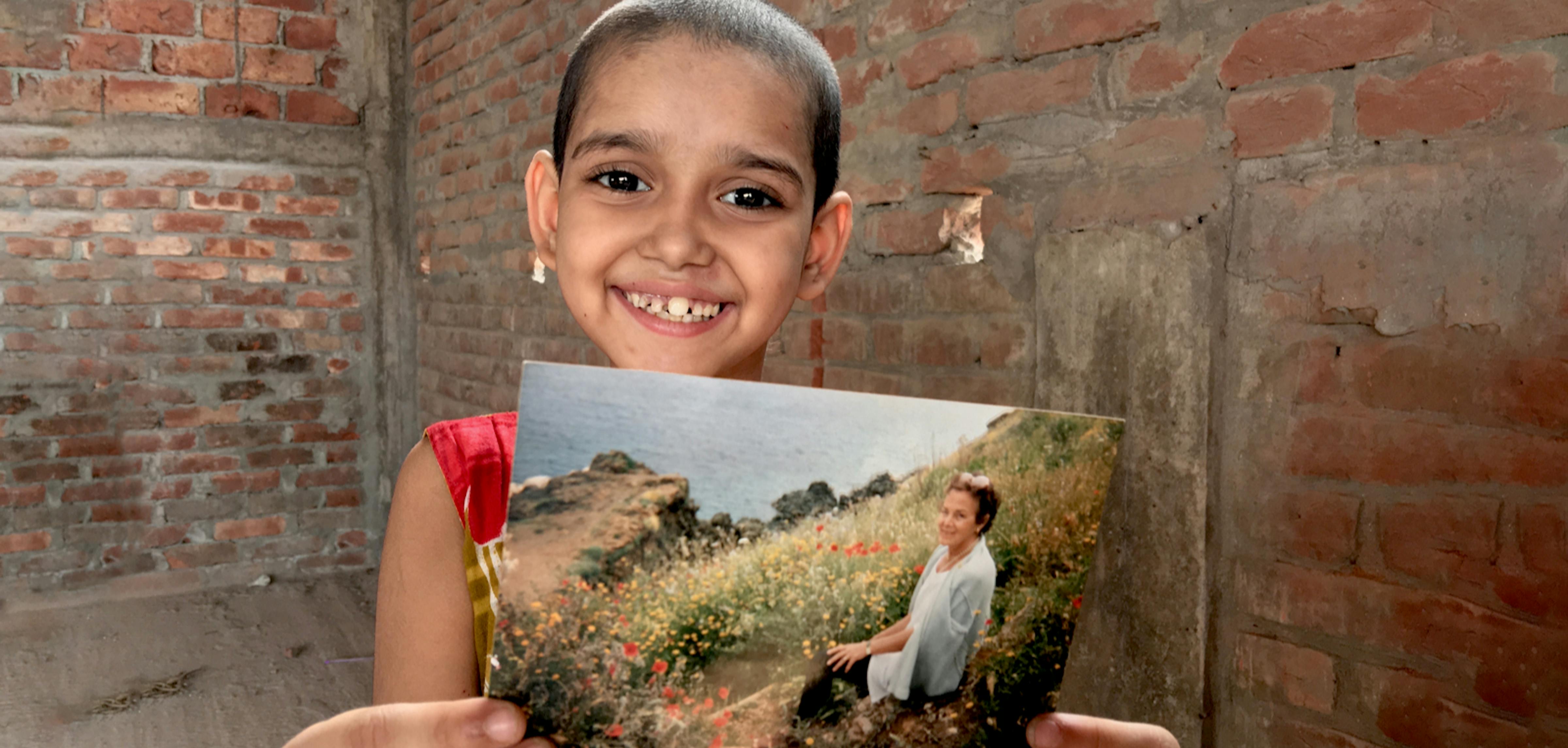 Bambina tiene in mano la foto di una donna 