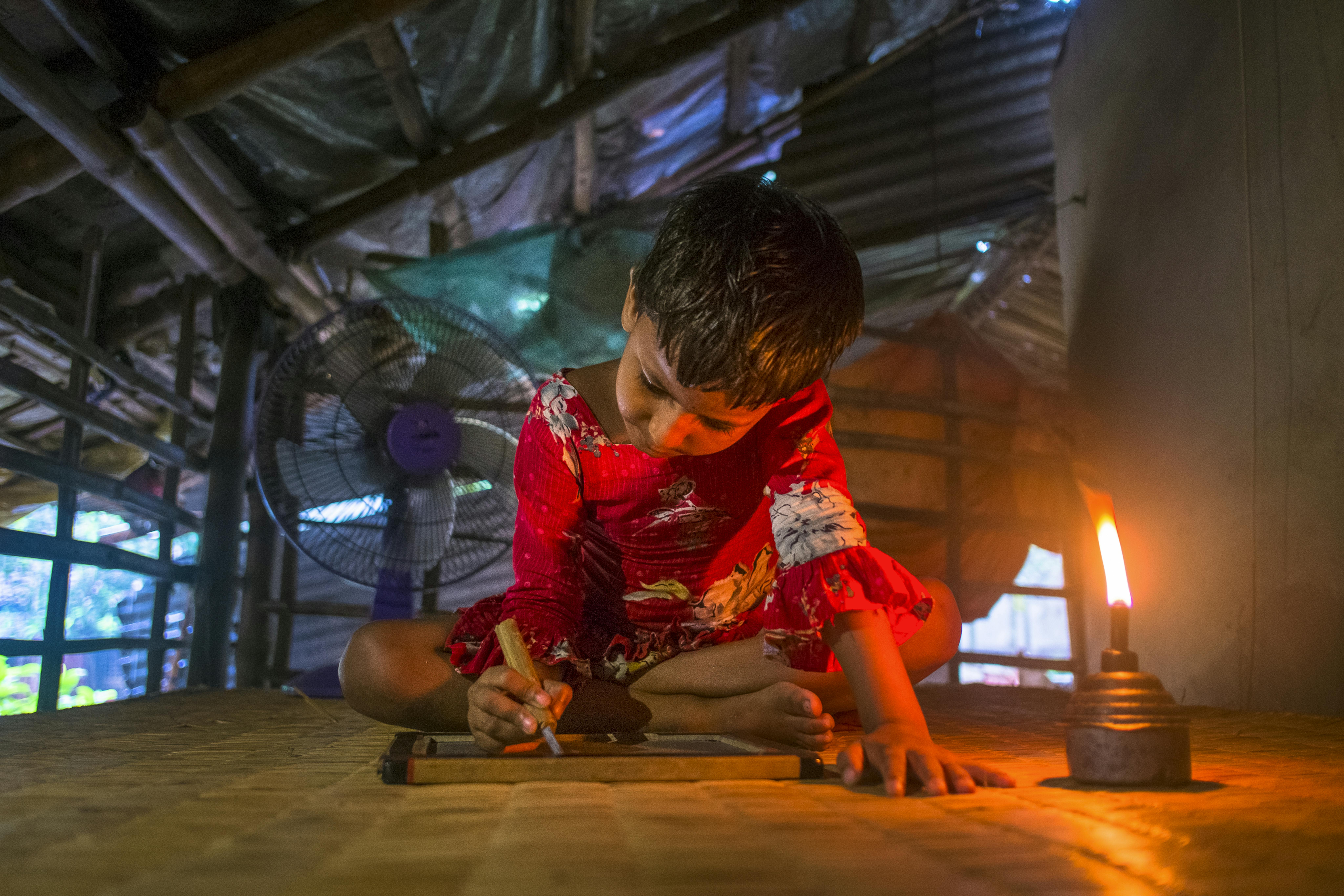 Bambina che fa i compiti nella sua casa in un piccolo villagio in Bangladesh