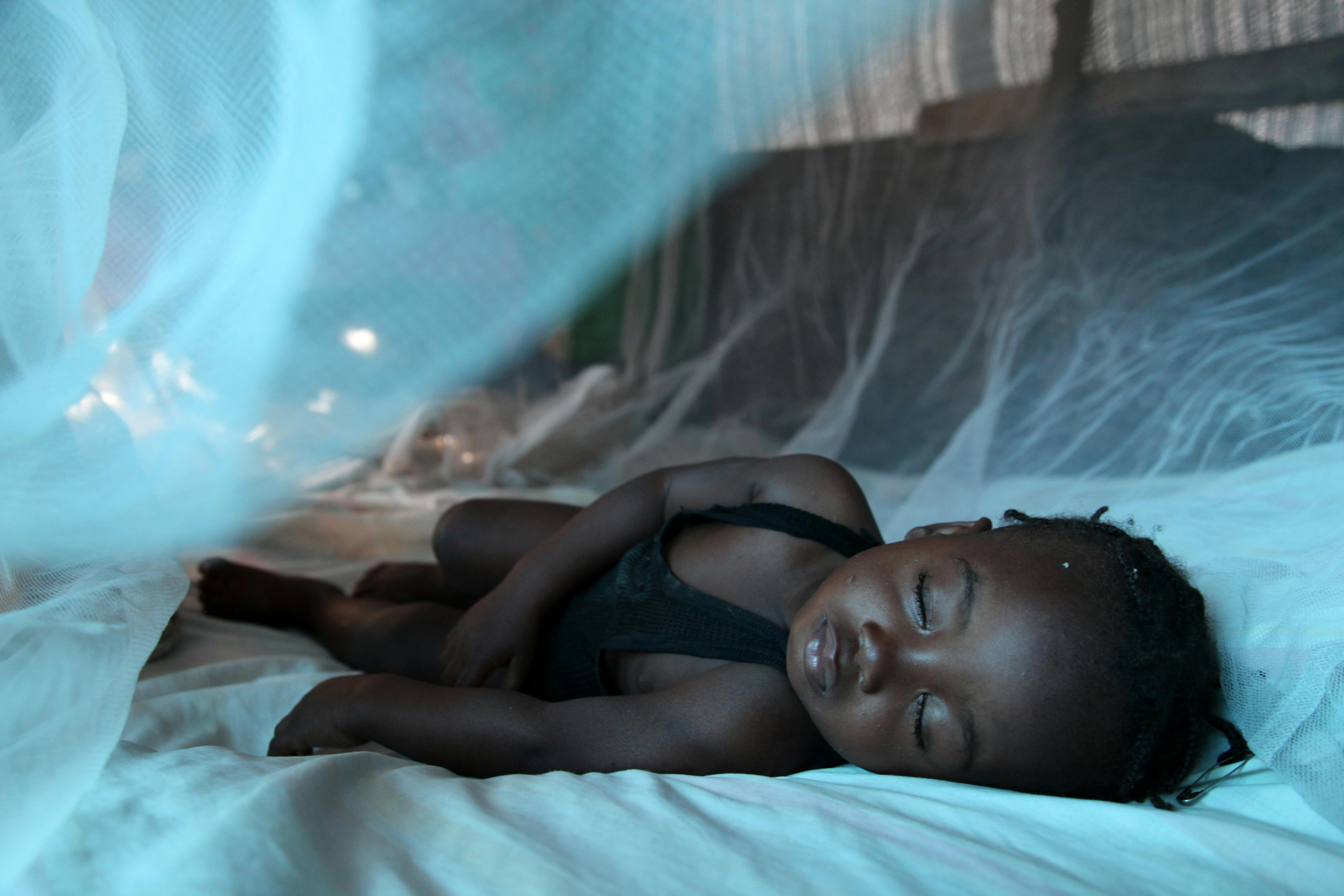 Bambina dorme sotto una zanzariera in un rifugio, ad Haithi