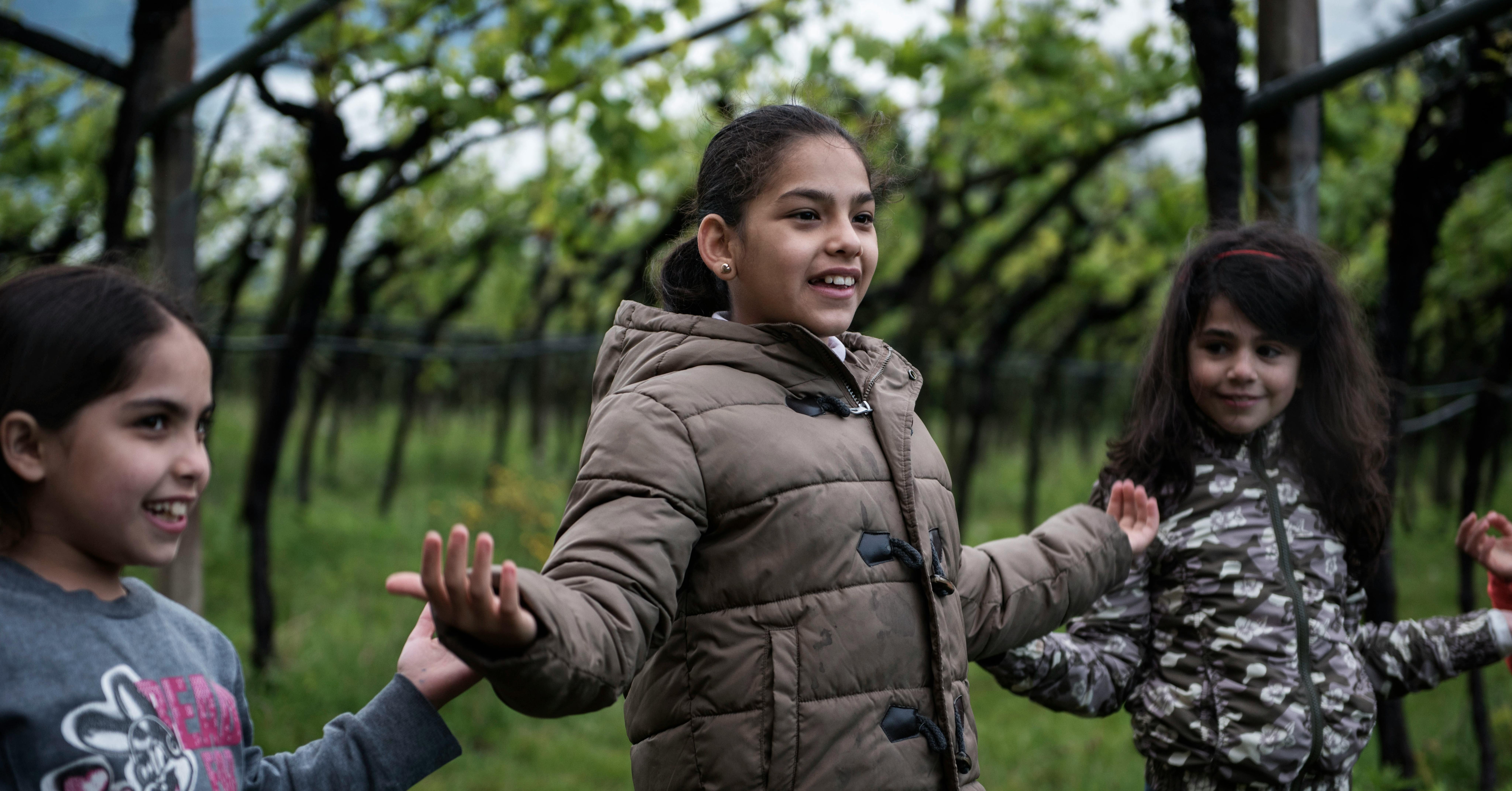 Una bambina di 9 anni, rifugiata siriana, gioca con le sue nuove amiche nella campagna vicino Trento