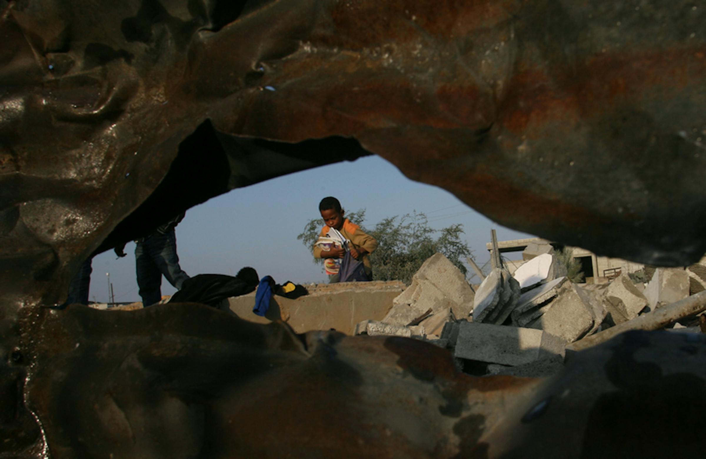 Ahmed (8 anni) recupera libri di scuola e vestiti tra le macerie della sua casa, rimasta distrutta dopo un raid aereo israeliano, nel villaggio di Khan Younis, nel sud della Striscia di Gaza - ©UNICEF/NYHQ2012-1580/El Baba