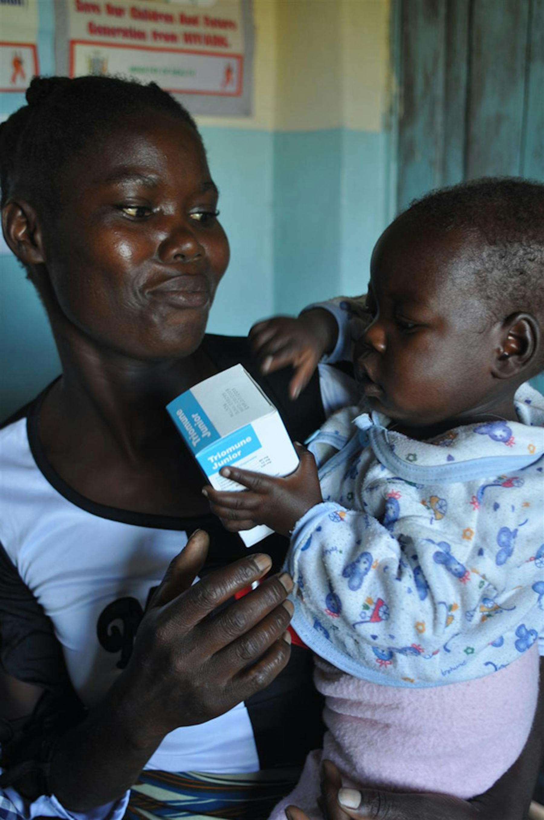 Bright, 21 mesi, stringe tra le mani una confezione di farmaci antiretrovirali, la stessa medicina che la sta proteggendo dal virus HIV che ha ereditato dalla mamma. Qui è con sua zia Leontine, nell'ospedale Chimebe (Zambia) - ©UNICEF/NYHQ2010-0871/Nesbitt