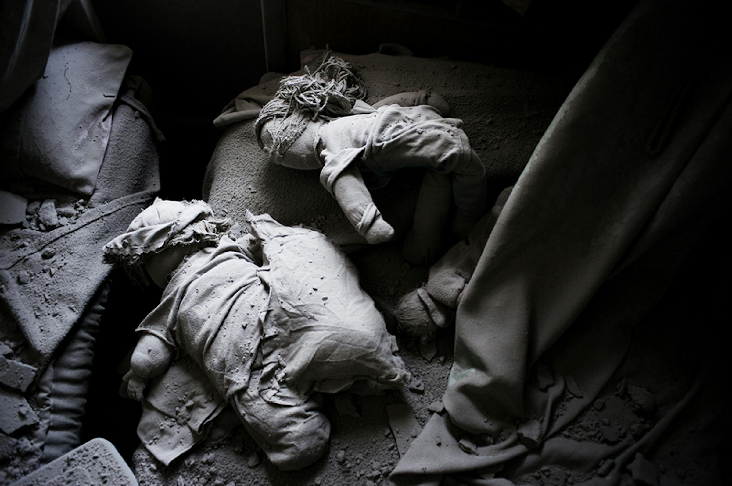Siria, bambole giacciono tra le macerie di una casa distrutta dai bombardamenti