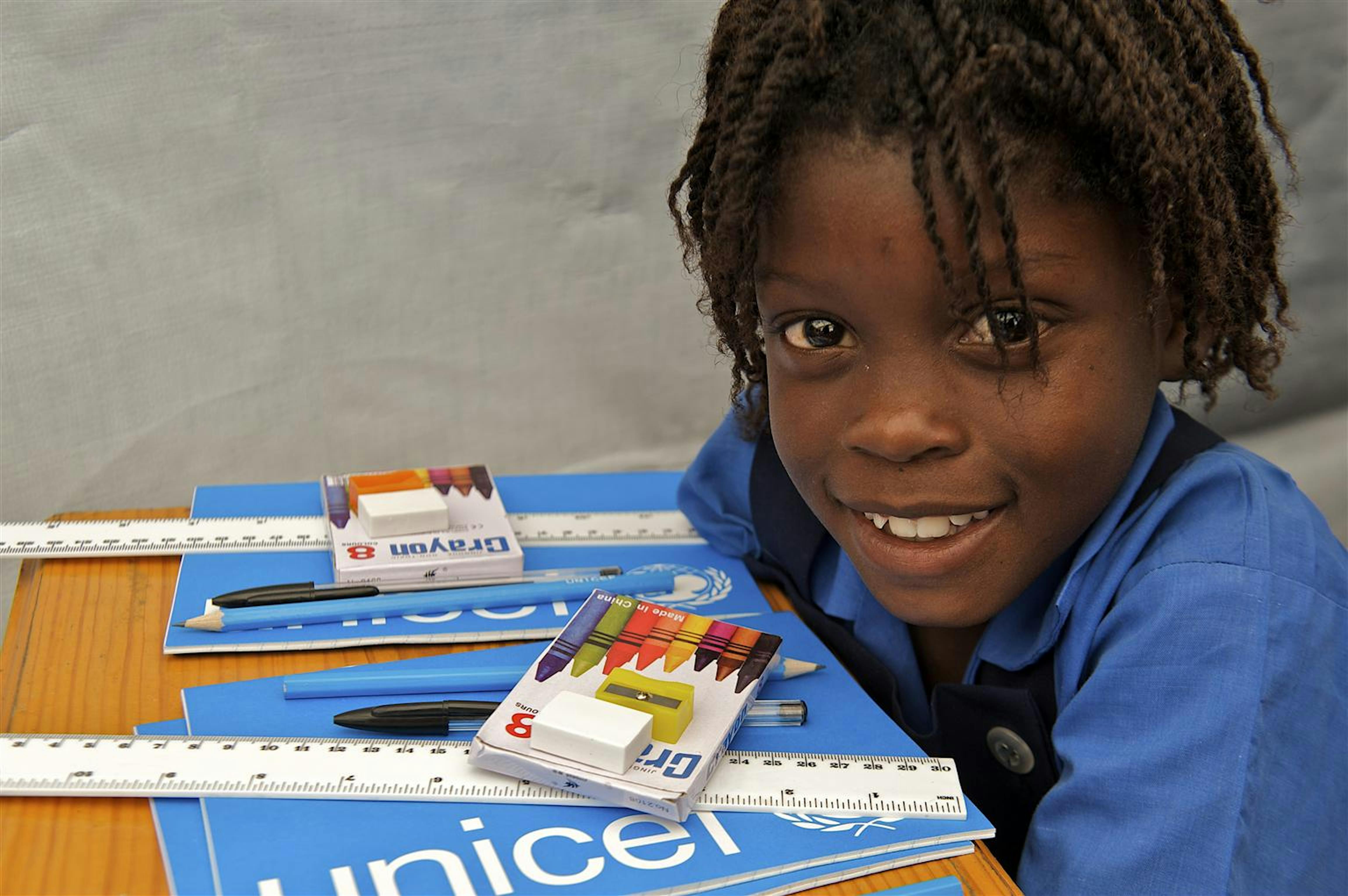 Nel villaggio rurale di Jacquot Merlin, vicino a Port-au Prince, una bambina frequenta la scuola utilizzando i quaderni UNICEF ©UNICEF/HQ10-0211/Noorani 