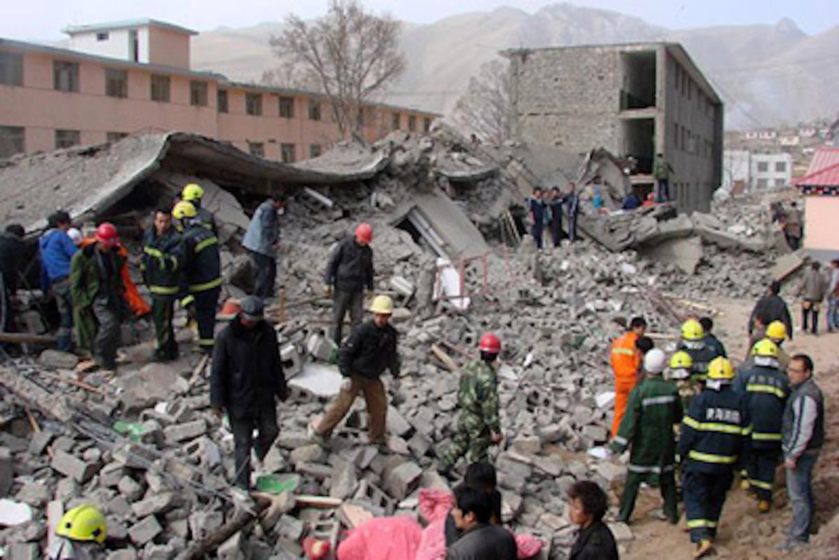 Soccorritori scavano tra le macerie di un edificio crollato a Yushu - ©AP Images
