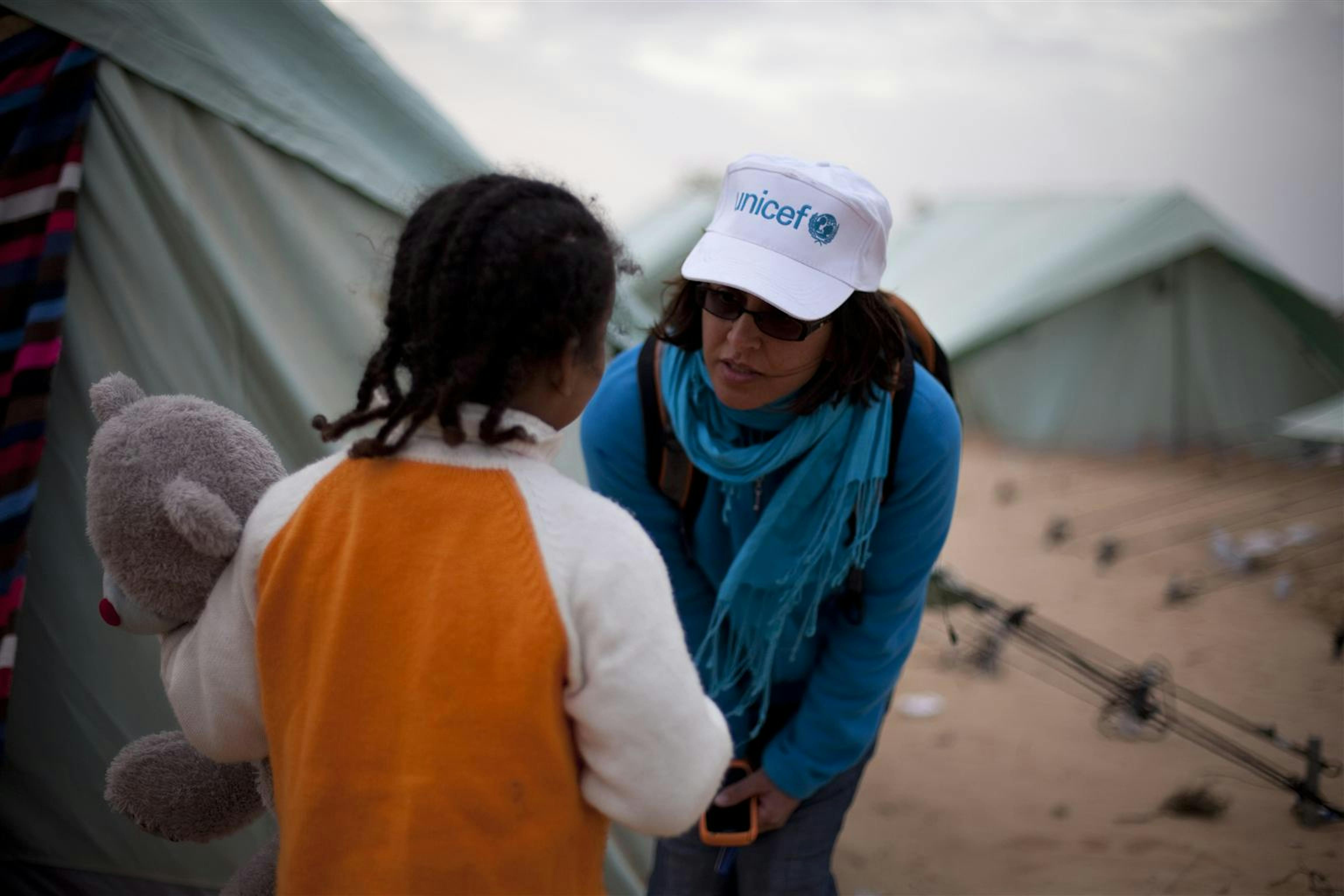 Najwa Mekki, operatrice UNICEF, accanto a Saida (6 anni) in un campo profughi presso il confine tra Libia e Tunisia. Saida, di origine somala, è una rifugiata sin dalla nascita - ©UNICEF/NYHQ2011-0412/Ramoneda