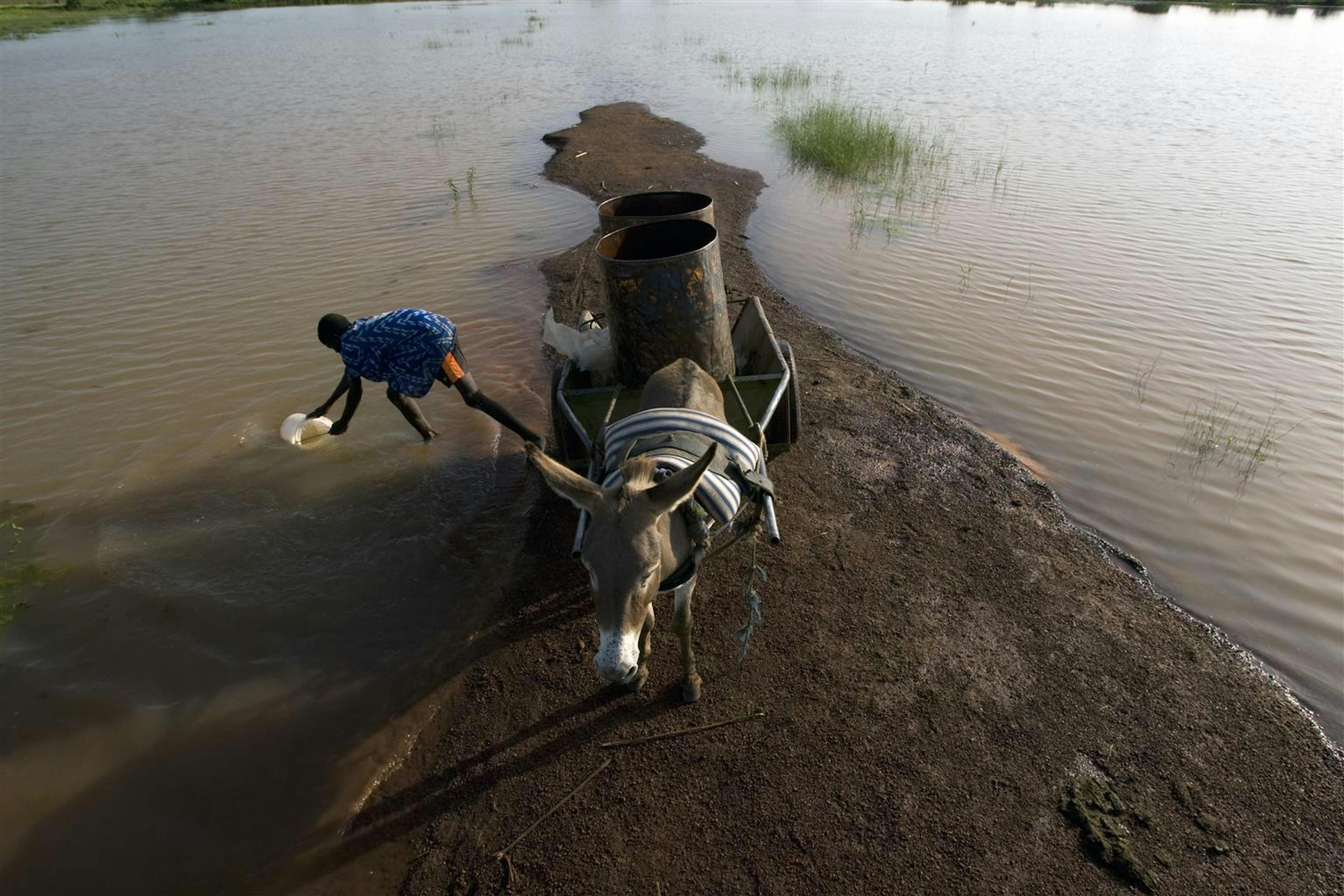 Un ragazzino raccoglie acqua da un fiume presso Savelugu, nel nord del Ghana. L'acqua non è potabile ed è contaminata da parassiti, ma sarà venduta nei villaggi vicini - ©UNICEF/NYHQ2008-0865/O.Asselin