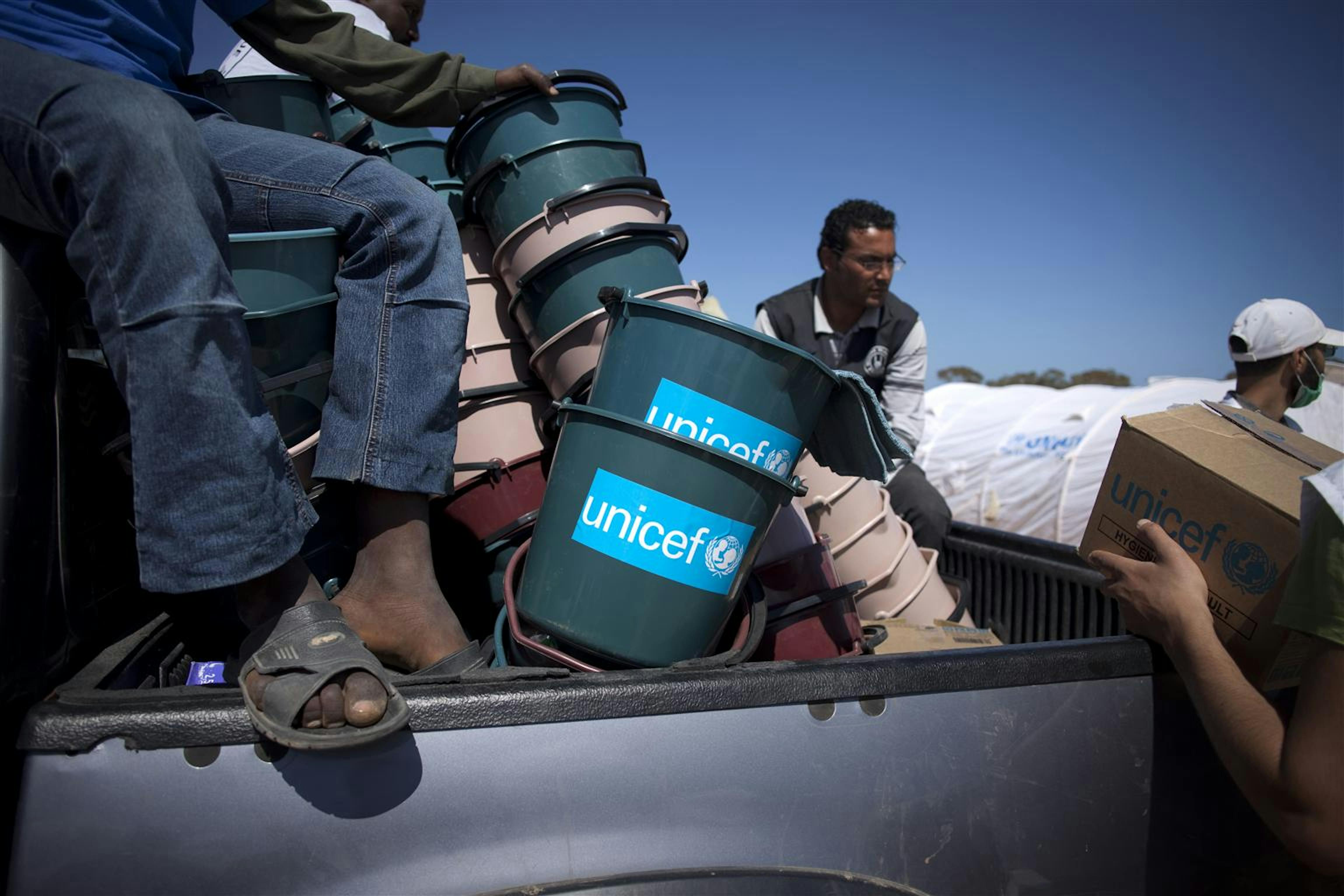 Un camion carico di aiuti UNICEF viene scaricato in un campo profughi al confine tunisino con la Libia - ©UNICEF/NYHQ2011-0508/M.Ramoneda