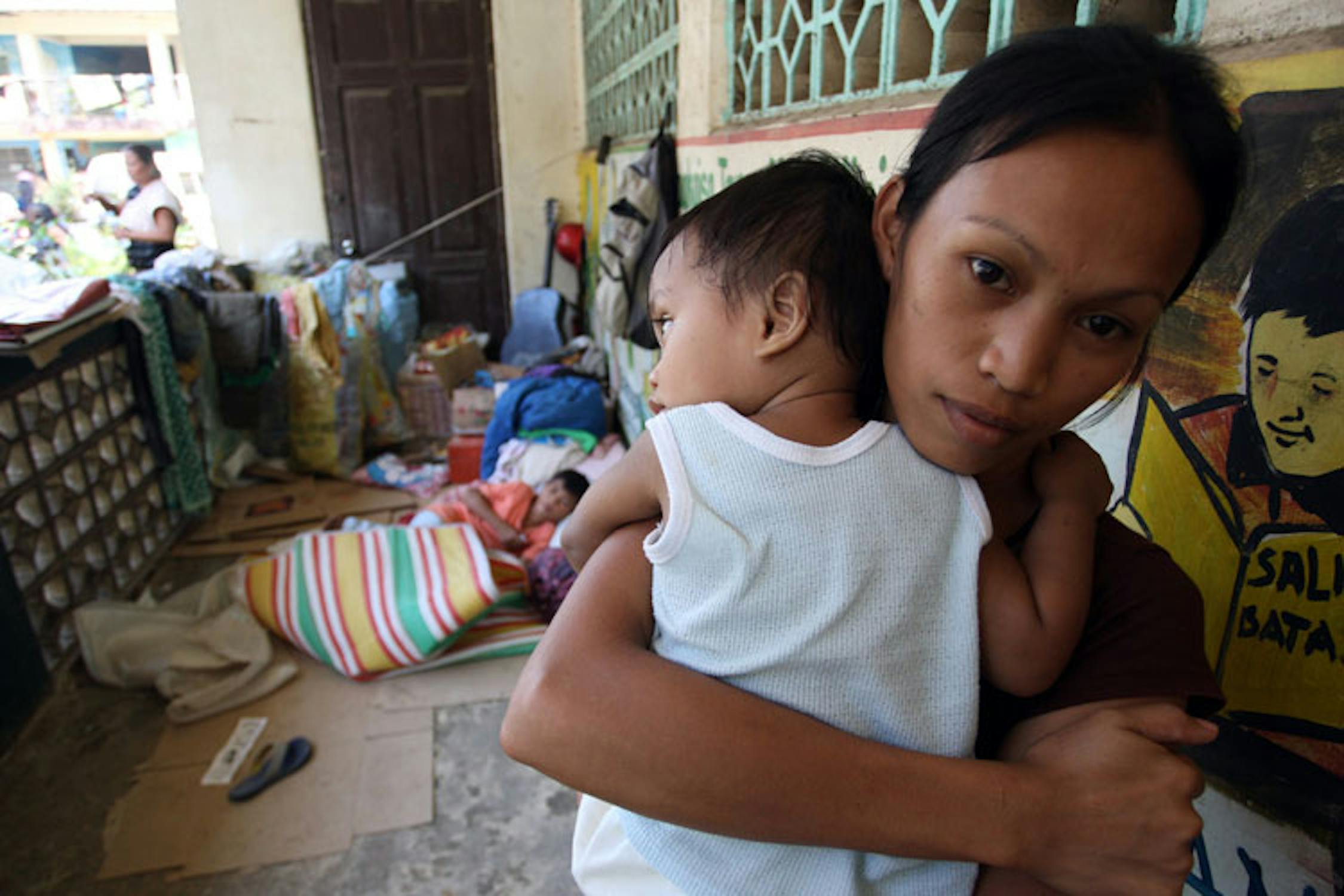 Rossie, 21 anni, stringe suo figlio Clifford (12 mesi) in un centro per sfollati di Cagayan de Oro, la città maggiormente colpita dalla tempesta Washi - ©UNICEF/NYHQ2011-2134/Maitum