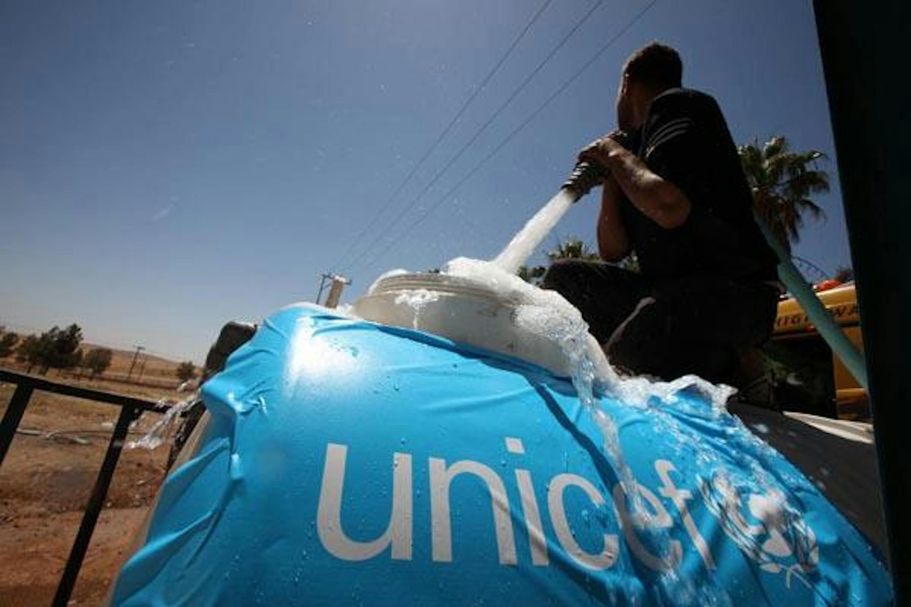 Campo Zaatari (Giordania). Un operatore UNICEF riempie un serbatoio d'acqua utile per soddisfare le esigenze igienico-sanitarie dei rifugiati. ©UNICEF