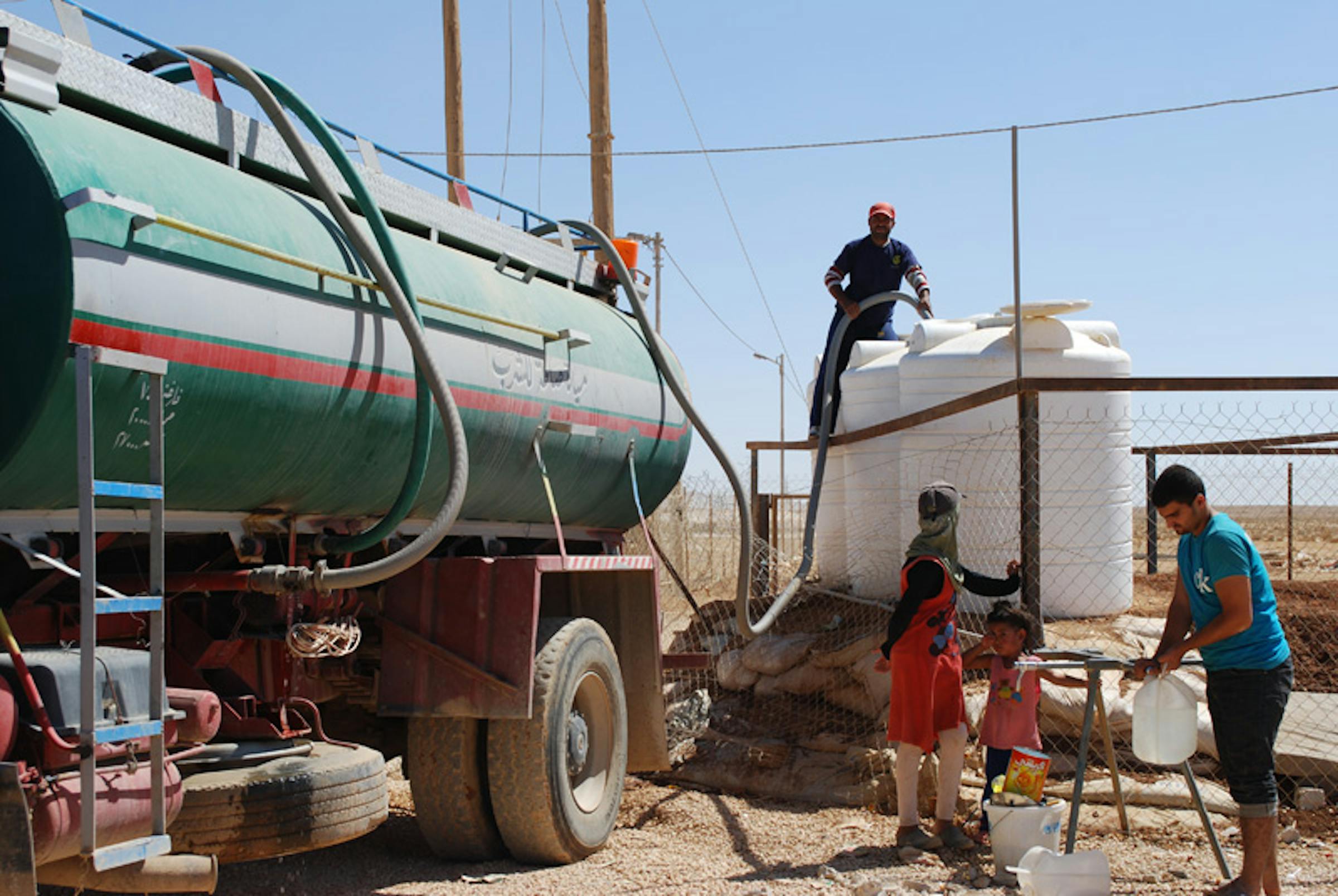 Un'autocisterna rifornisce di acqua potabile alcuni serbatoi del campo profughi di Za'atari, nel deserto della Giordania, che ospita decine di migliaia di siriani - ©UNICEF Giordania/2012/Al Masri