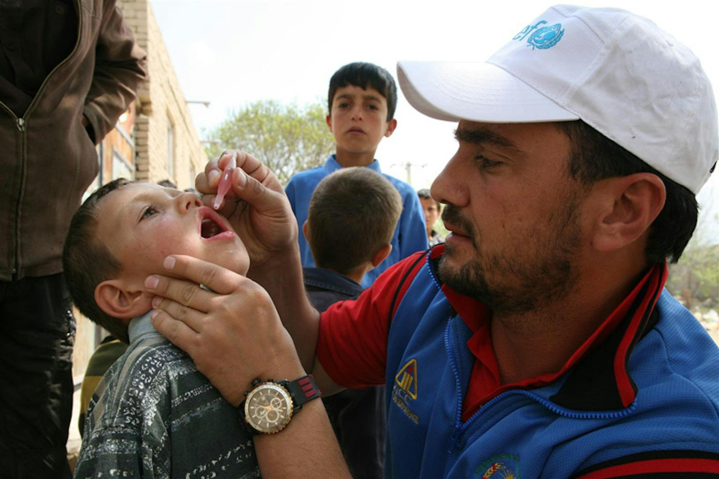Il campione afgano di cricket e Ambasciatore UNICEF Raees Ahmadzai vaccina un bambino contro la polio durante la Settimana Mondiale delle Vaccinazioni 2012 - ©UNICEF Afghanistan/2012-0038/A.Frutan