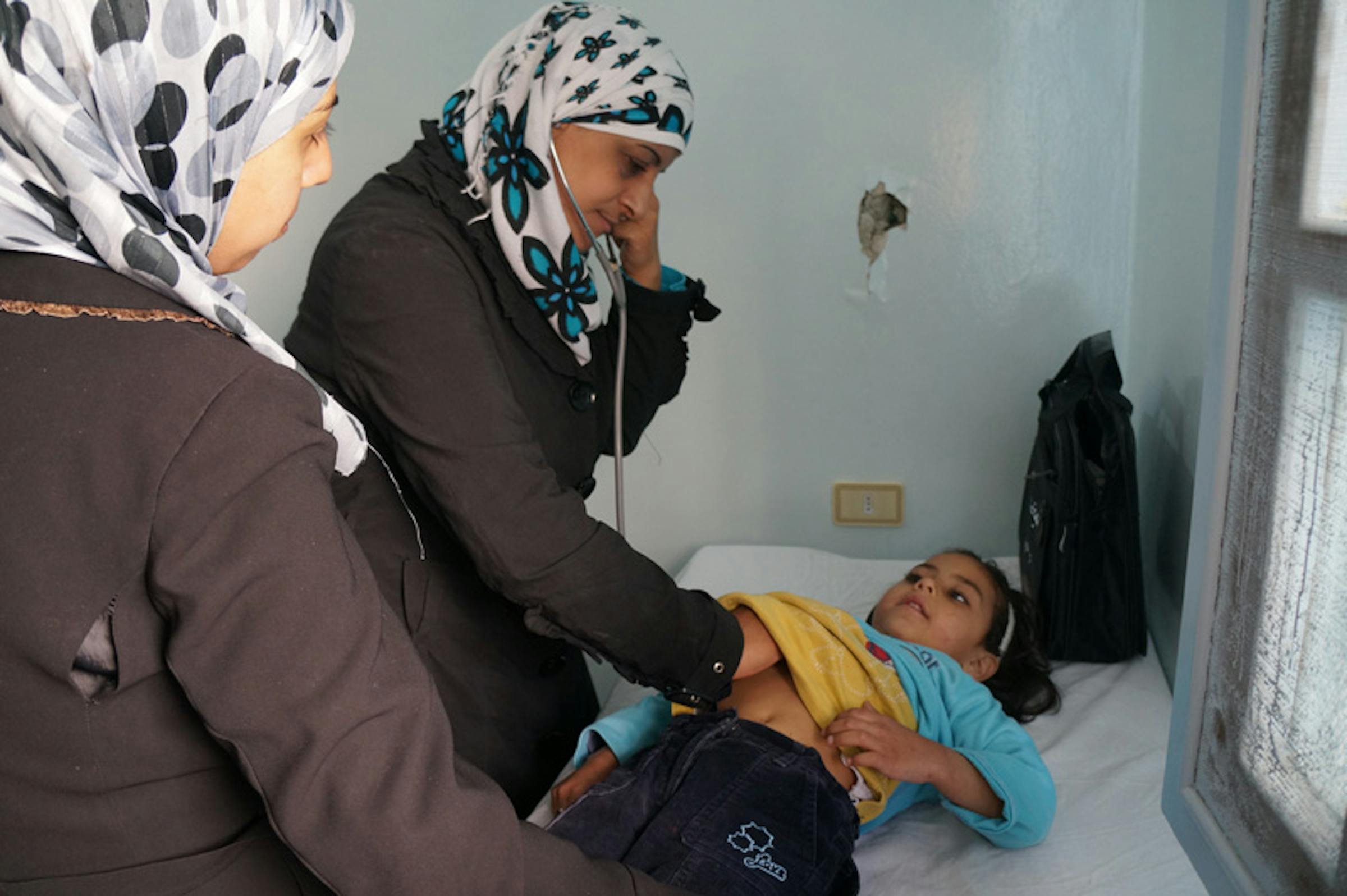 Una dottoressa esamina con lo stetoscopio una bambina in un piccolo ospedale di Homs, una delle città più martoriate dalla guerra che da oltre due anni dilania la Siria - ©UNICEF/NYHQ2013-0203/I.Morooka