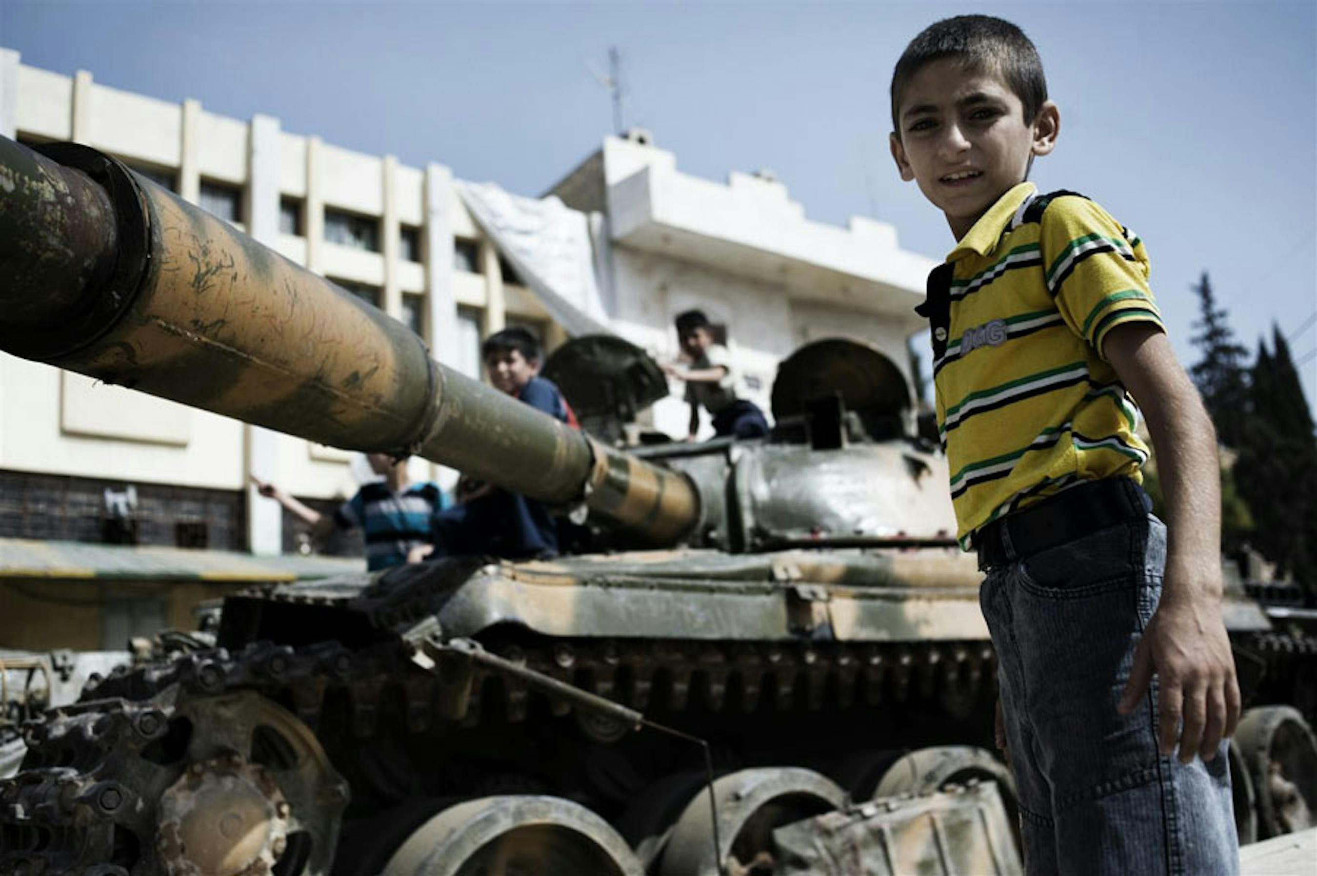 Un bambino accanto a un carro armato in una via di Aleppo, Siria - ©UNICEF/NYHQ2012-1300/Alessio Romenzi