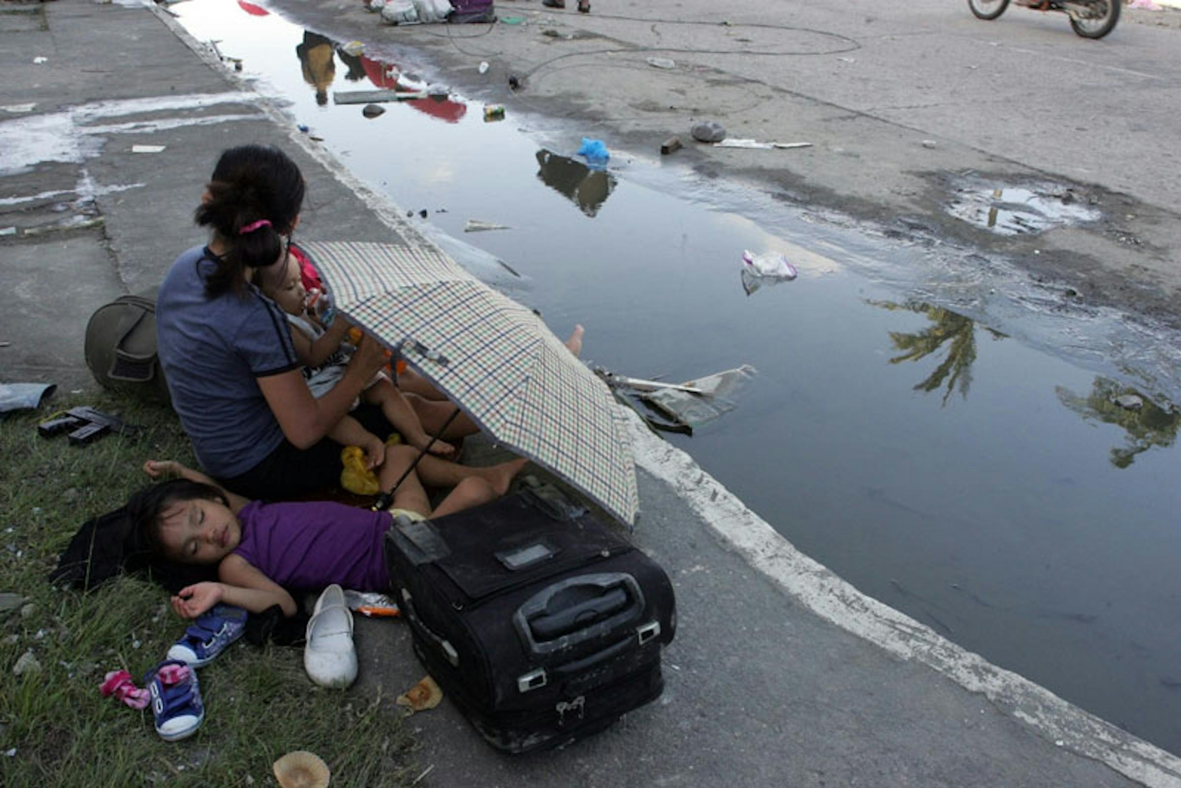 Madre e figli a Tacloban City, Filippine. Sono almeno 100.000 i bambini sotto i 5 anni senza tetto nelle aree colpite dal tifone Haiyan - ©UNICEF/NYHQ2013-0995/J.Maitem
