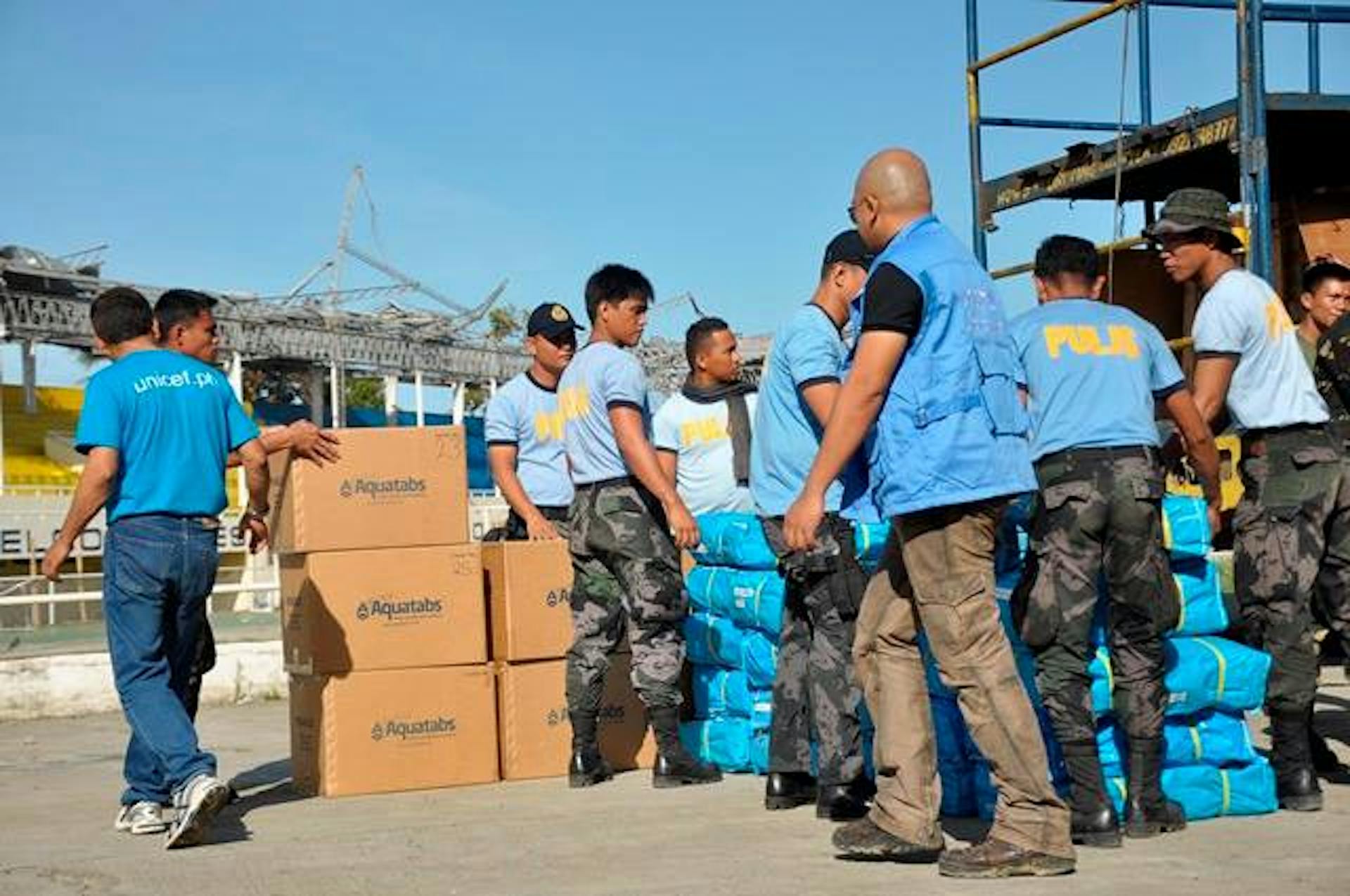 Militari e operatori civili scaricano scorte di sostanze per potabilizzare l'acqua fornite dall'UNICEF nella città di Roxas - ©UNICEF Filippine/2013/Ivan Hibalo