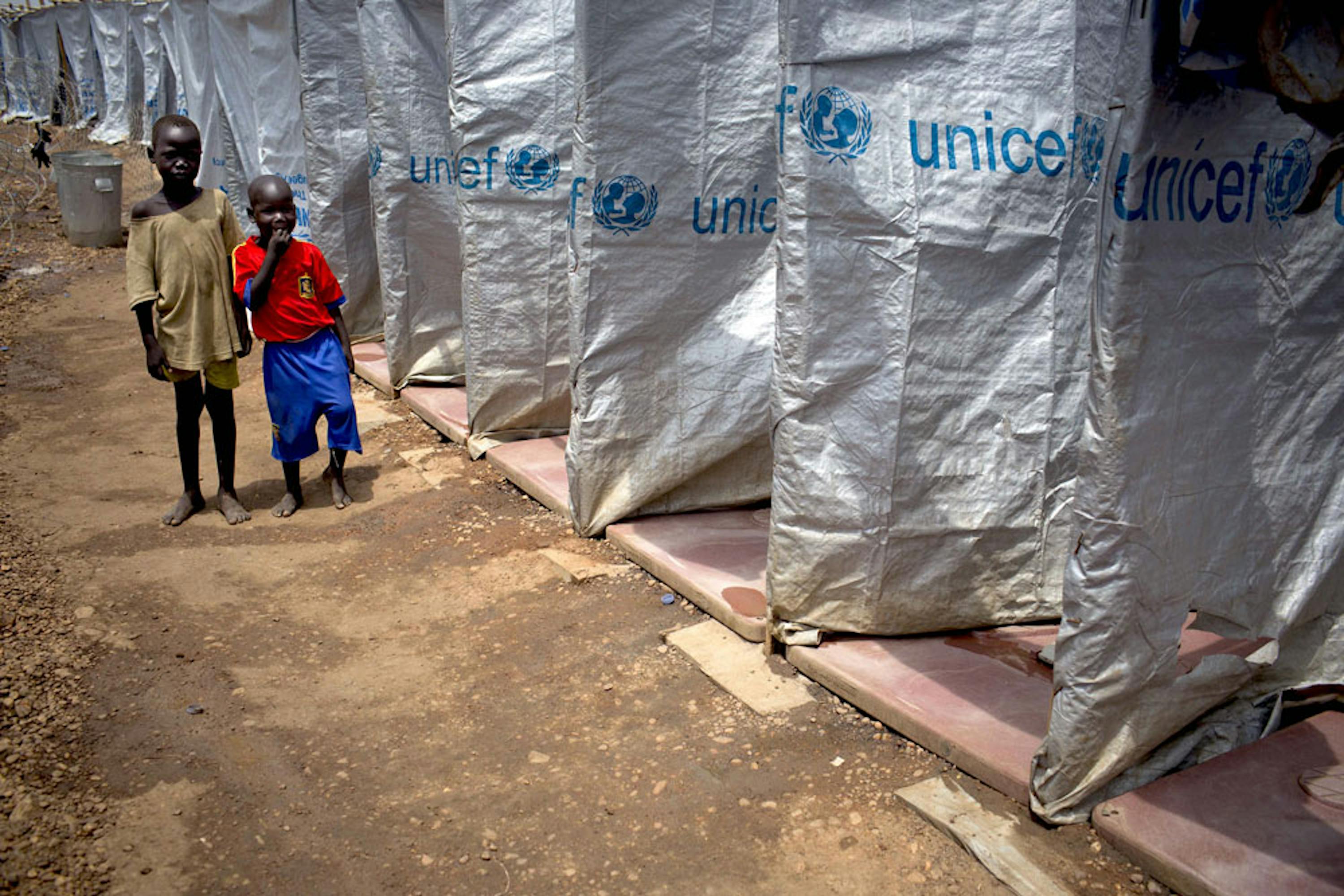 Bambini accanto a una serie di latrine installate dall'UNICEF intorno alla base militare di Tomping (Sud Sudan) dove si sono rifugiati migliaia di sfollati - ©UNICEF/NYHQ2014-0337/Holt