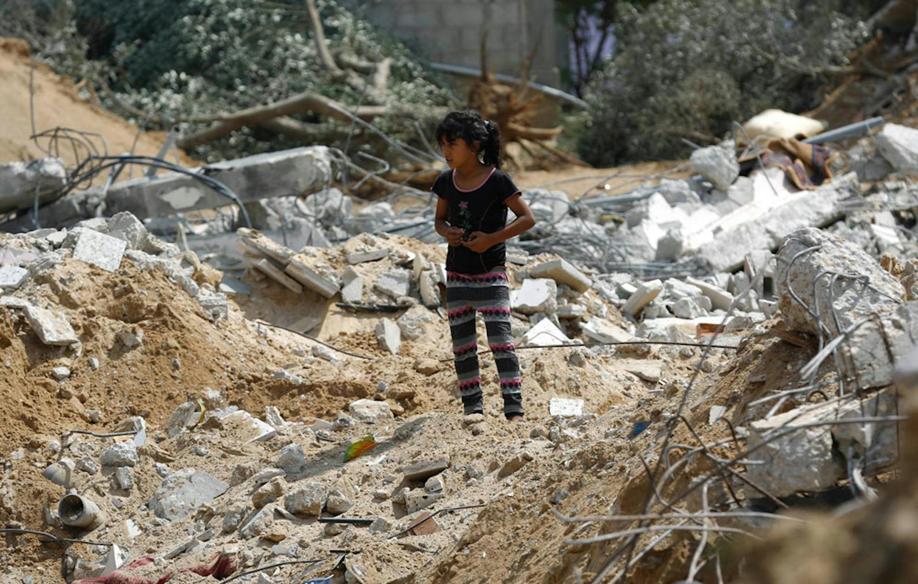 Una bambina fra le macerie della palazzina di tre piani in cui viveva, nella città di Khan Yunis (nel sud della Striscia di Gaza), rasa al suolo da un raid israeliano il 20 luglio scorso - ©UNICEF/NYHQ2014-1003/Iyad El Baba