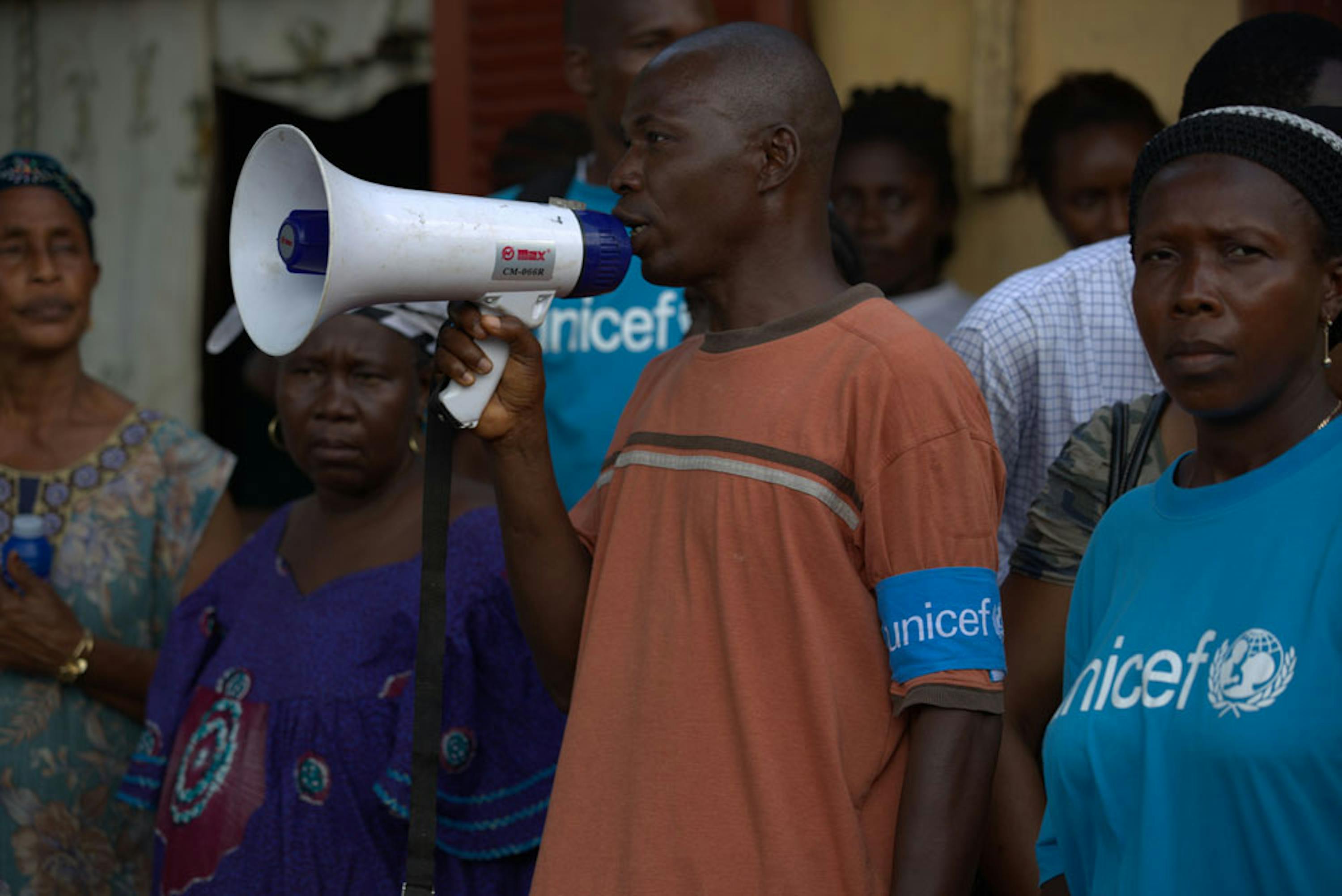 Volontari della ONG locale AJCOM impegnati in un'attività di informazione pubblica su come evitare il contagio di Ebola in una piazza di Conakry (Guinea). L'attività è svolta sotto l'egida dell'UNICEF - ©UNICEF/NYHQ2014-1529/Timothy La Rose