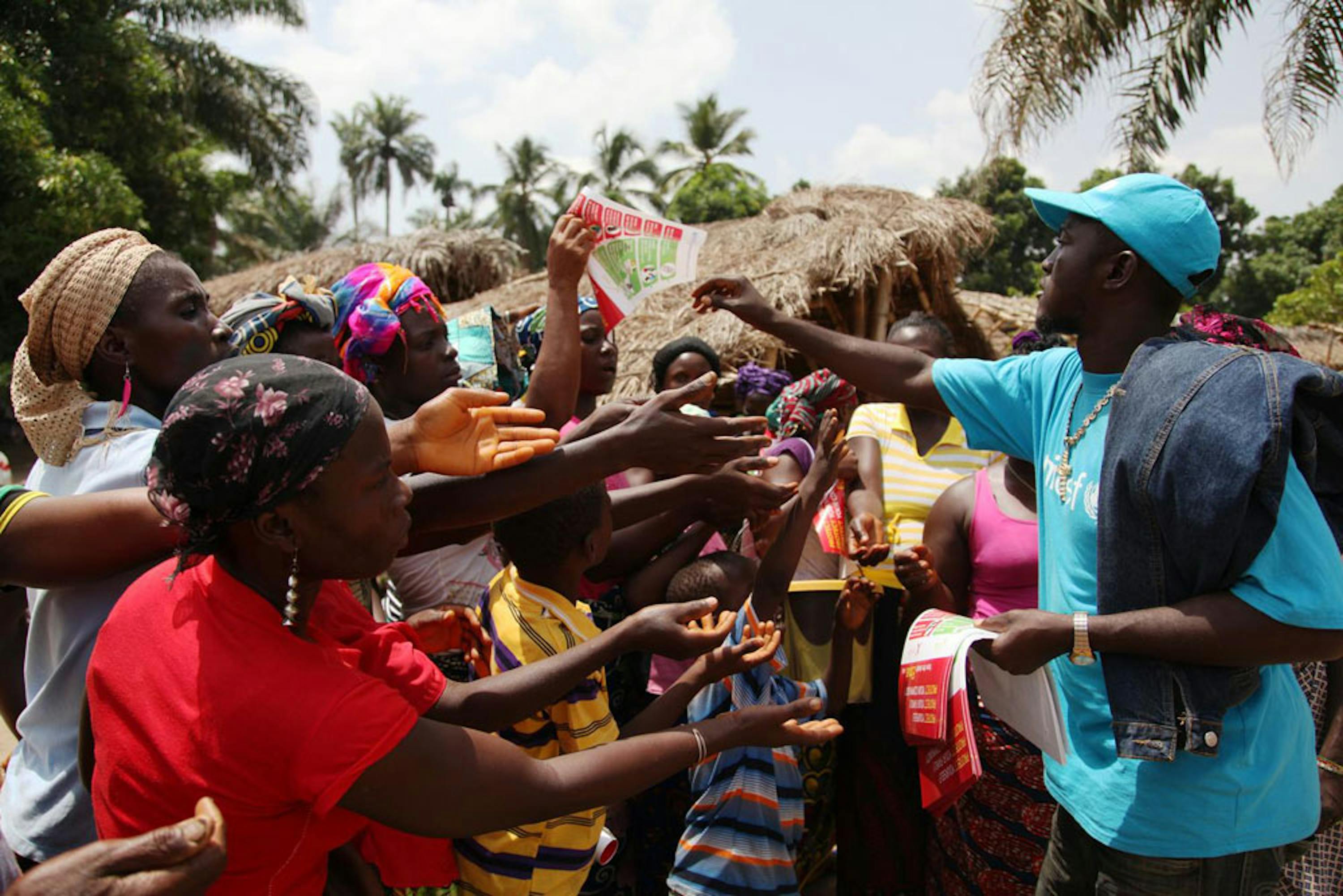 Un'immagine simbolo di questo 2014: un operatore UNICEF nel corso di una campagna di informazione sanitaria di emergenza sul pericolo Ebola in un villaggio della Liberia - ©UNICEF/UNI167524/Ahmed Jallanzo