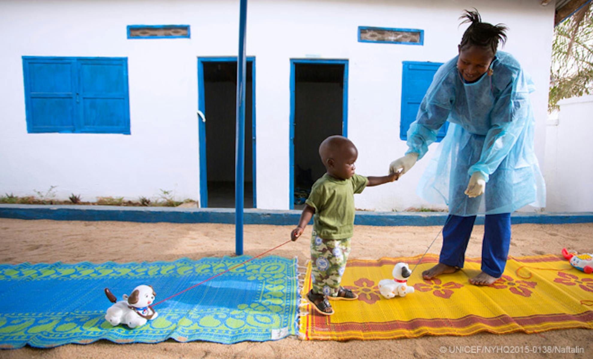 Bambino e infermiera in un centro di isolamento per sospetti casi di Ebola in Guinea. Il centro è sostenuto economicamente e tecnicamente dall'UNICEF - ©UNICEF/2015