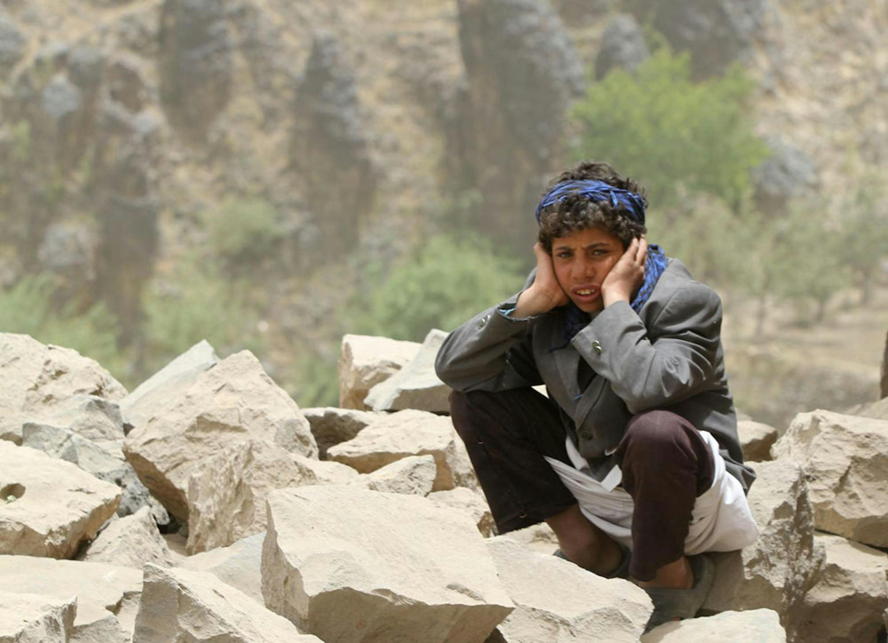 Un ragazzo seduto fra le macerie della sua abitazione, rasa al suolo da un raid aereo nel villaggio di Okash, nel sud dello Yemen - ©UNICEF/NYHQ2015-0857/Hamoud