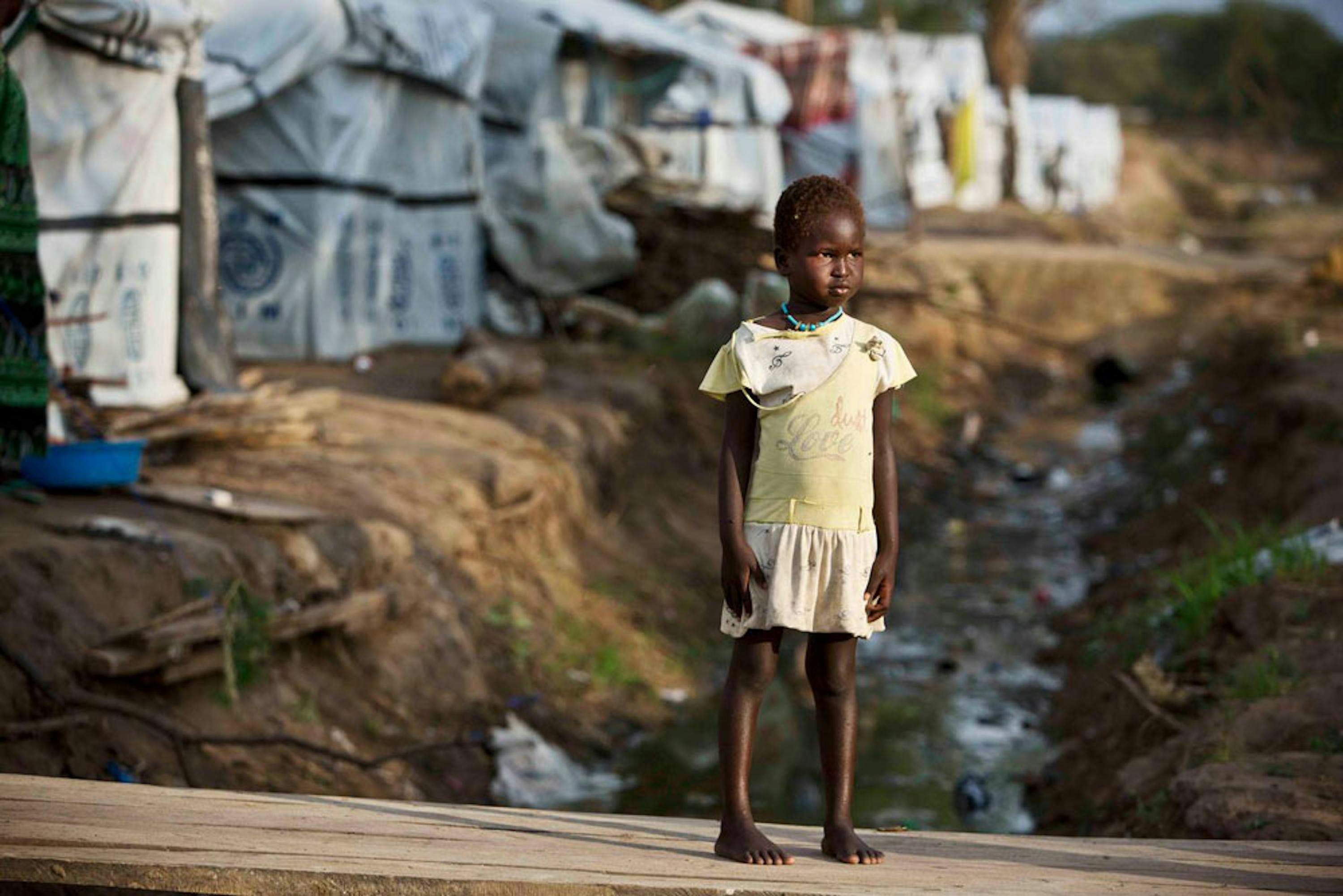 Un bambino nell'area per la Protezione dei civili (PoC) di Bor, nello stato di Jonglei (Sud Sudan): si intravede la fogna a cielo aperto - ©UNICEF/UNI176405/Holt