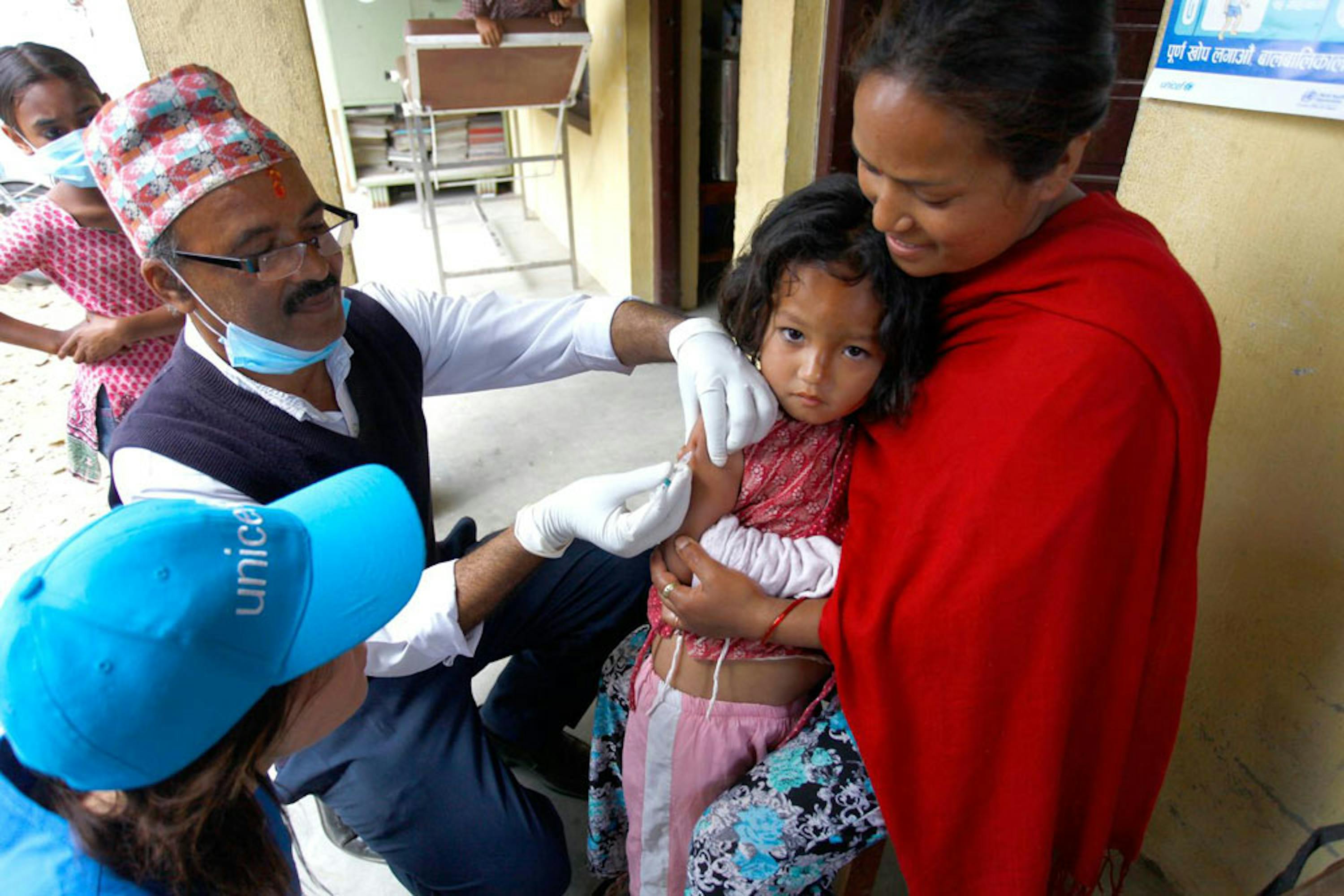 Neisha, 4 anni, viene vaccinata contro il morbillo. Dal giorno del terremoto Neisha e la sua famiglia vivono all'aperto, in una fattoria nel villaggio di Bungamati (Nepal) - ©UNICEF/NYHQ2015-1107/Panday