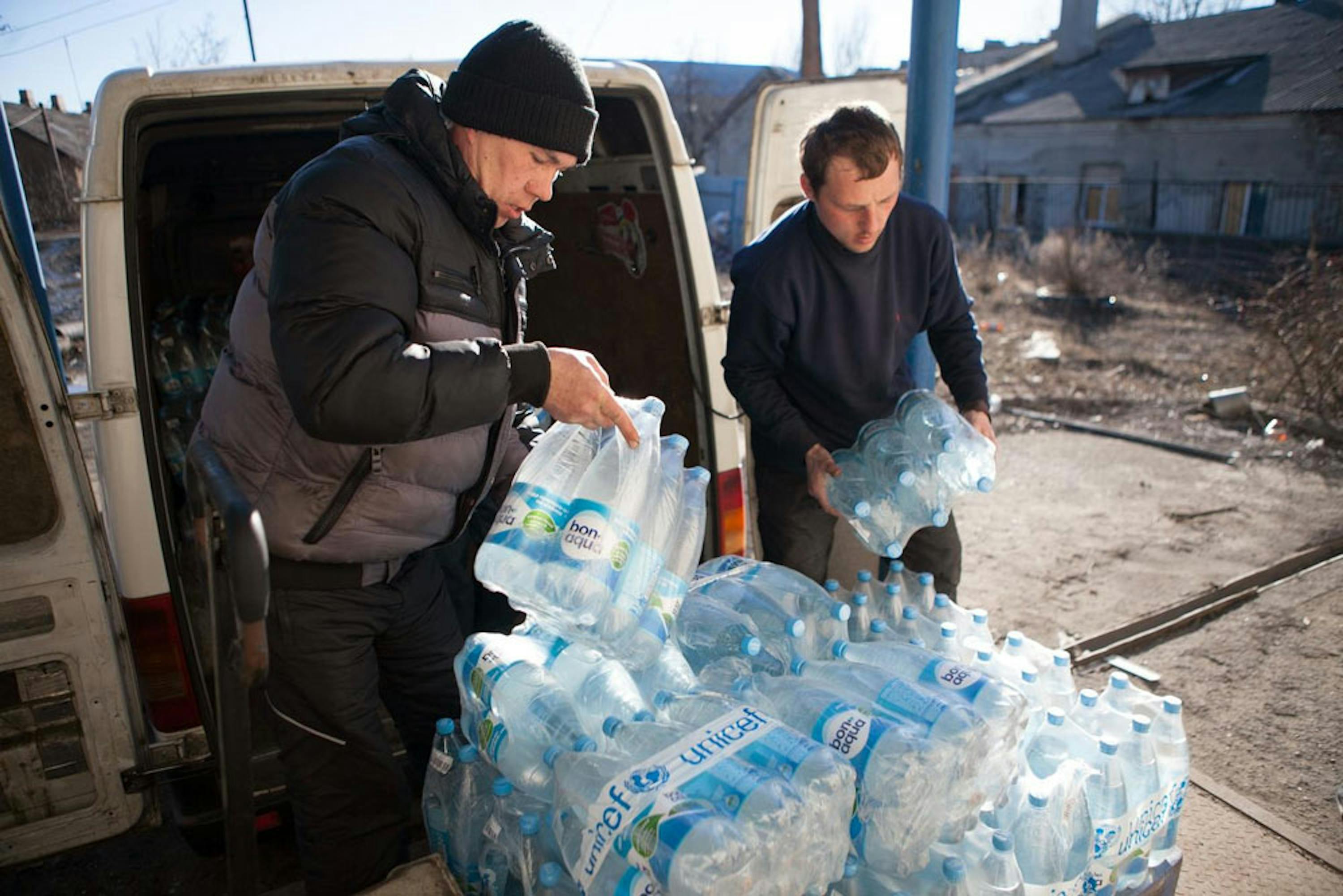 Una scena frequente da mesi, nell'est dell'Ucraina: volontari UNICEF distribuiscono acqua in una zona teatro di combattimenti - ©UNICEF/NYHQ2015-0279/Filippov