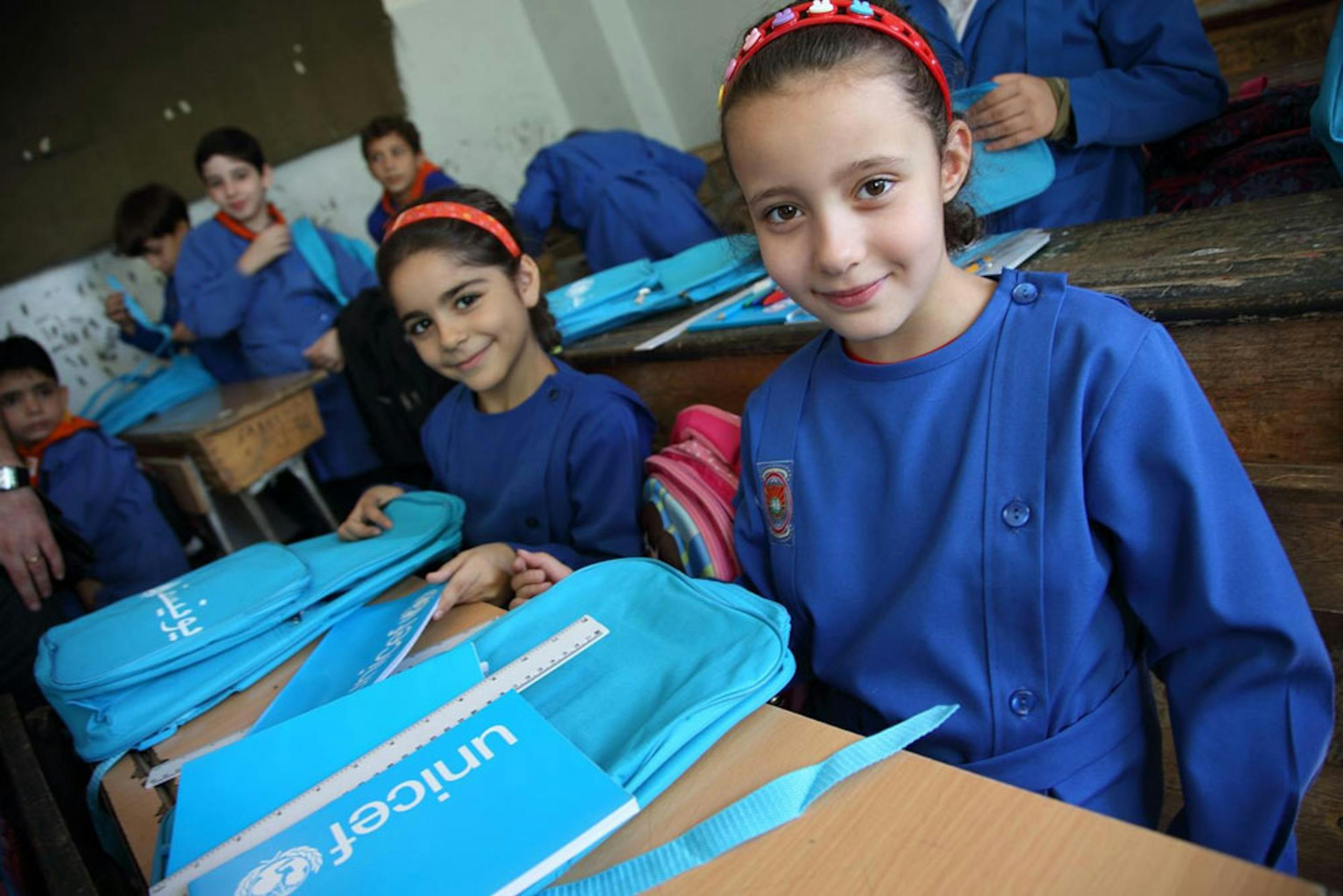 Bambine di terza elementare di una scuola di Damasco con zainetti e materiali didattici donati dall'UNICEF - ©UNICEF/NYHQ2014-1738/Sonoda