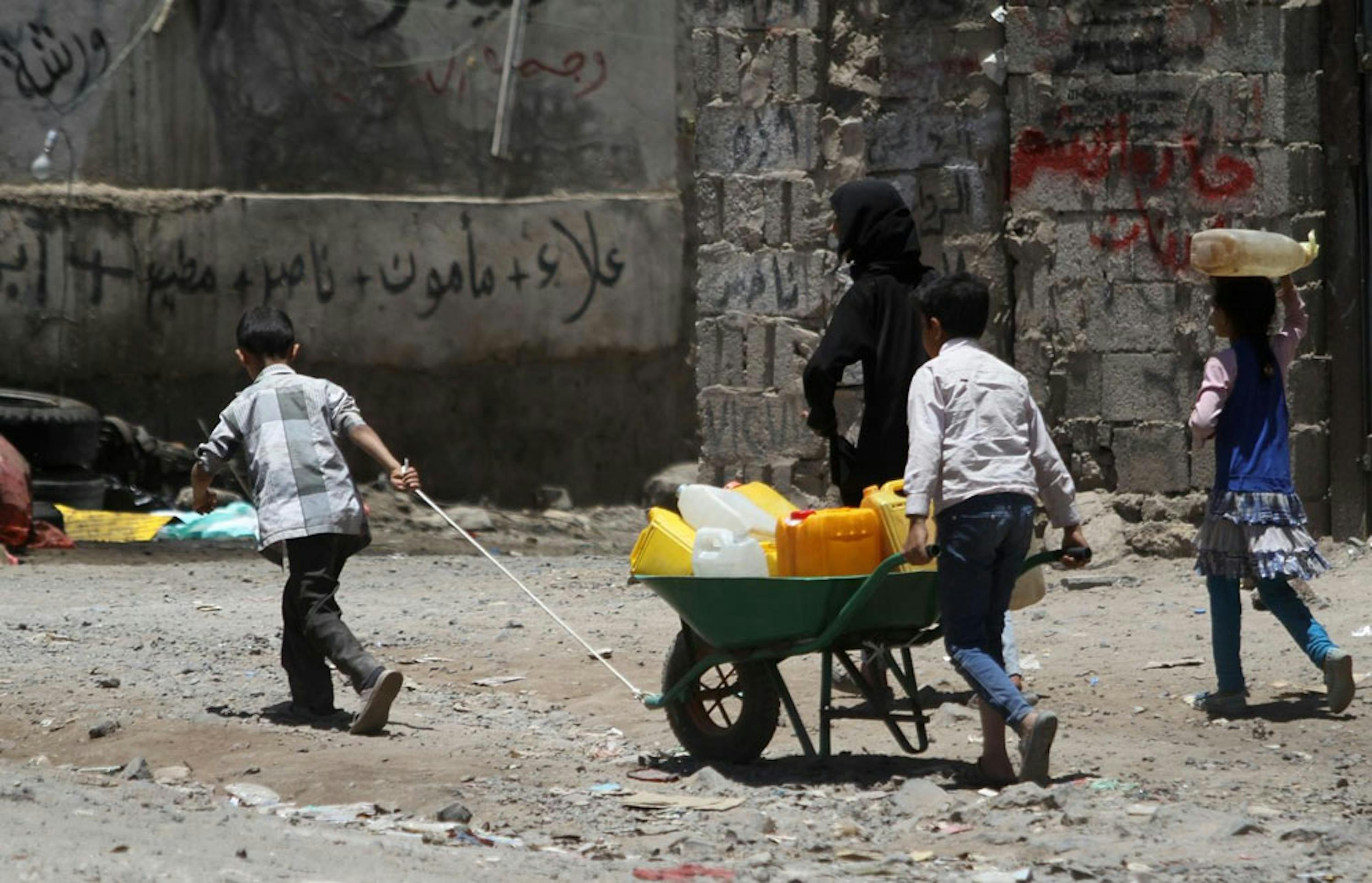 Bambini spingono una carriola piena di taniche in una strada di Sana'a, capitale dello Yemen. La ricerca dell'acqua è una delle preoccupazioni più pressanti per la popolazione civile in questi mesi di guerra - ©UNICEF/UNI184984/Mohammed Yasin