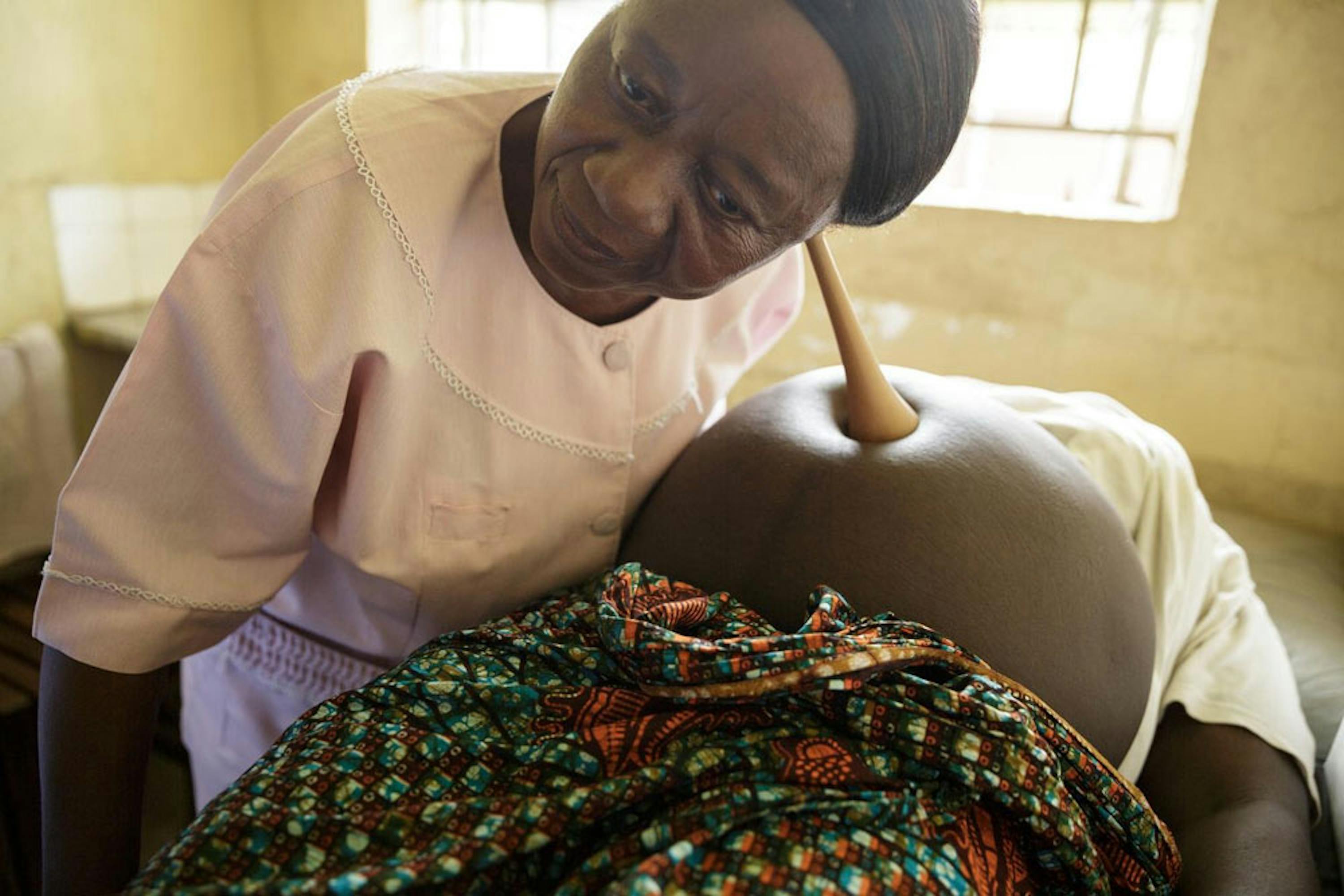 Un'ostetrica controlla il battito fetale durante una visita prenatale nell'ospedale di Kenema, in Sierra Leone. La struttura sanitaria è stata finanziata in larga parte dai donatori italiani dell'UNICEF - ©UNICEF Sierra Leone/2013-0579/Asselin