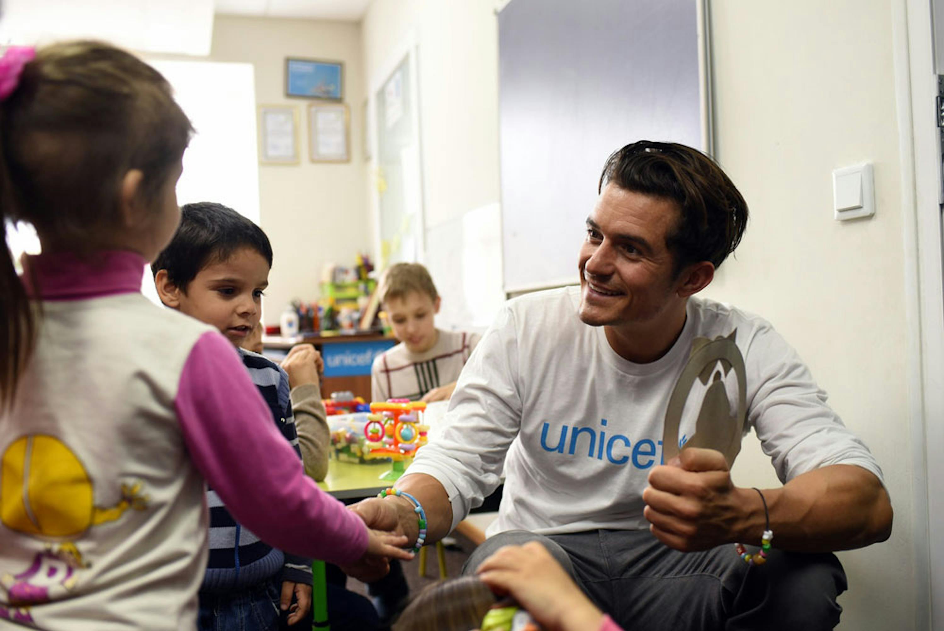 Orlando Bloom con alcuni dei 40 bambini che ogni giorno frequentano il centro ricreativo per bambini sfollati di Svjatogorsk (Ucraina) - ©UNICEF/UN017900/Georgiev