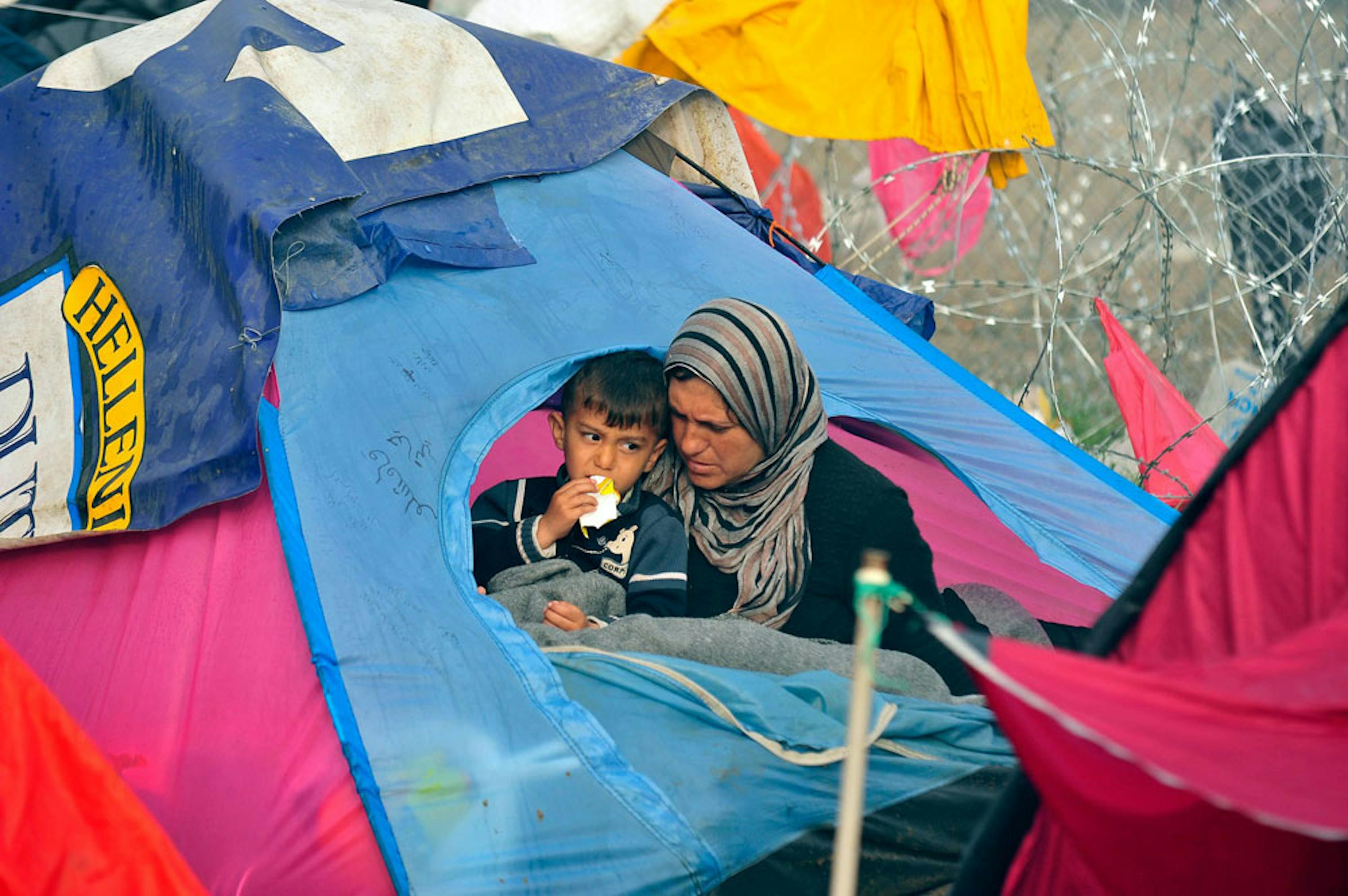 Una donna e il suo bambino all'ingresso della loro tenda a Idomeni, al confine tra Grecia e Macedonia - ©UNICEF/UN012799/Georgiev