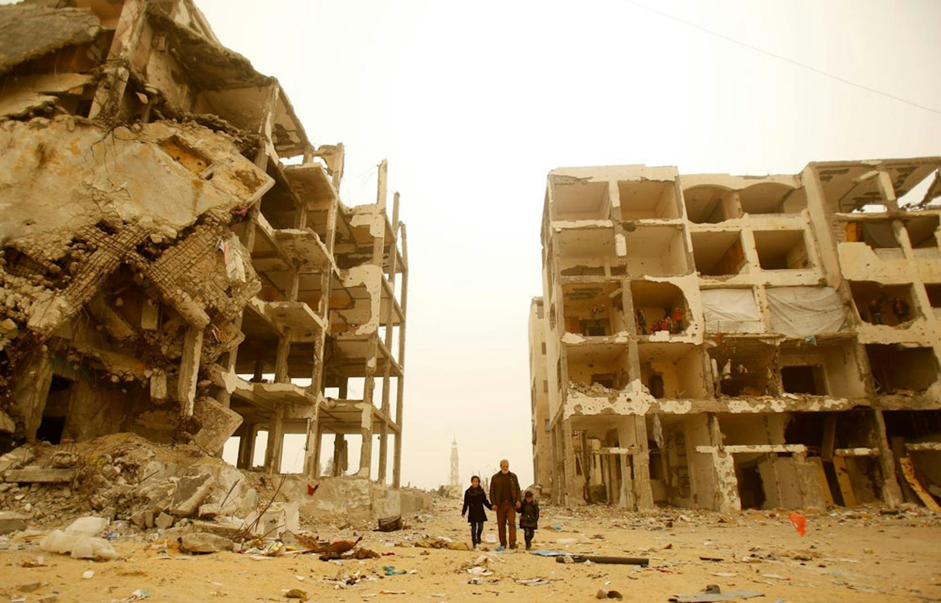 Samar (11 anni) e Rosol (6) passeggiano con il nonno fra le macerie del palazzo in cui vivevano a Beit Lahia, nella Striscia di Gaza, distrutto dai bombardamenti nel 2014 - ©UNICEF/UNI179592/El Baba