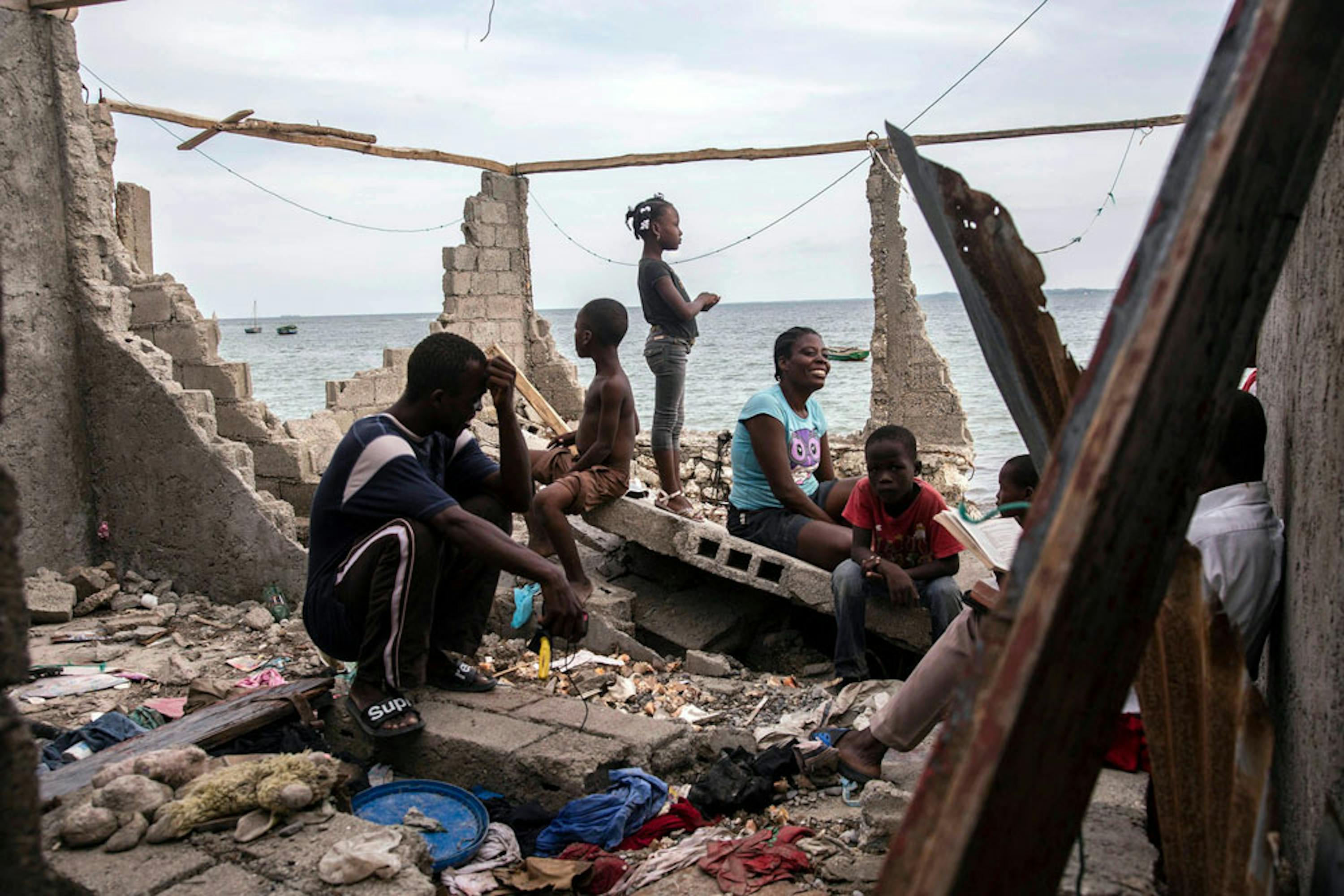 César, Eminiemme e i loro bambini fra le rovine di La Savane, sobborgo della città di Les Cayes, la città più colpita dall'uragano Matthew ad Haiti - ©UNICEF/UN035145/LeMoyne