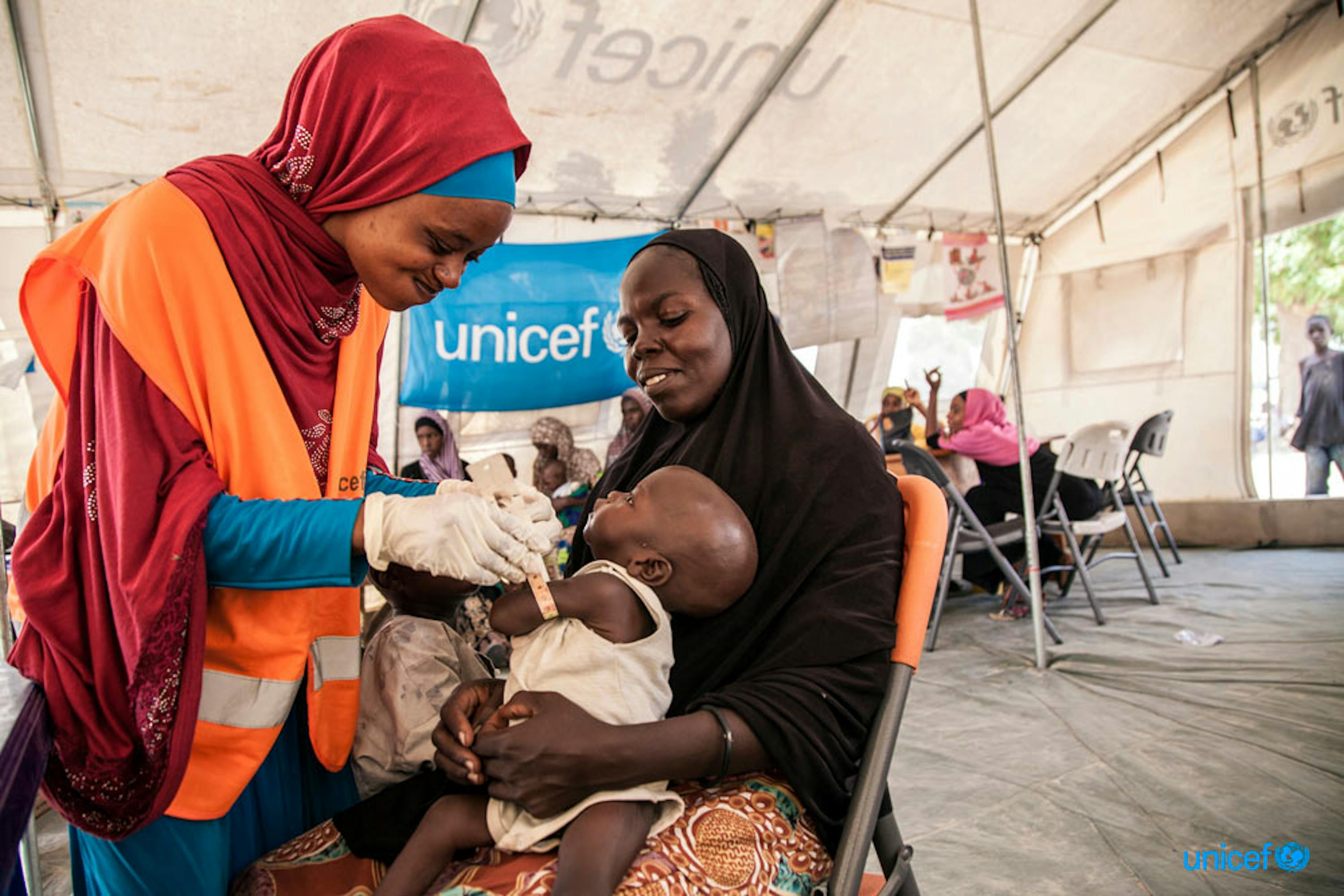 Umara (7 mesi) viene visitato da una nutrizionista dell'UNICEF a Maiduguri (Nigeria). Dall'inizio dell'anno sono 117.000 i bambini nel Nord-Est del paese che sono stati curati da gravi forme di malnutrizione - © UNICEF/UN041140/Vittozzi