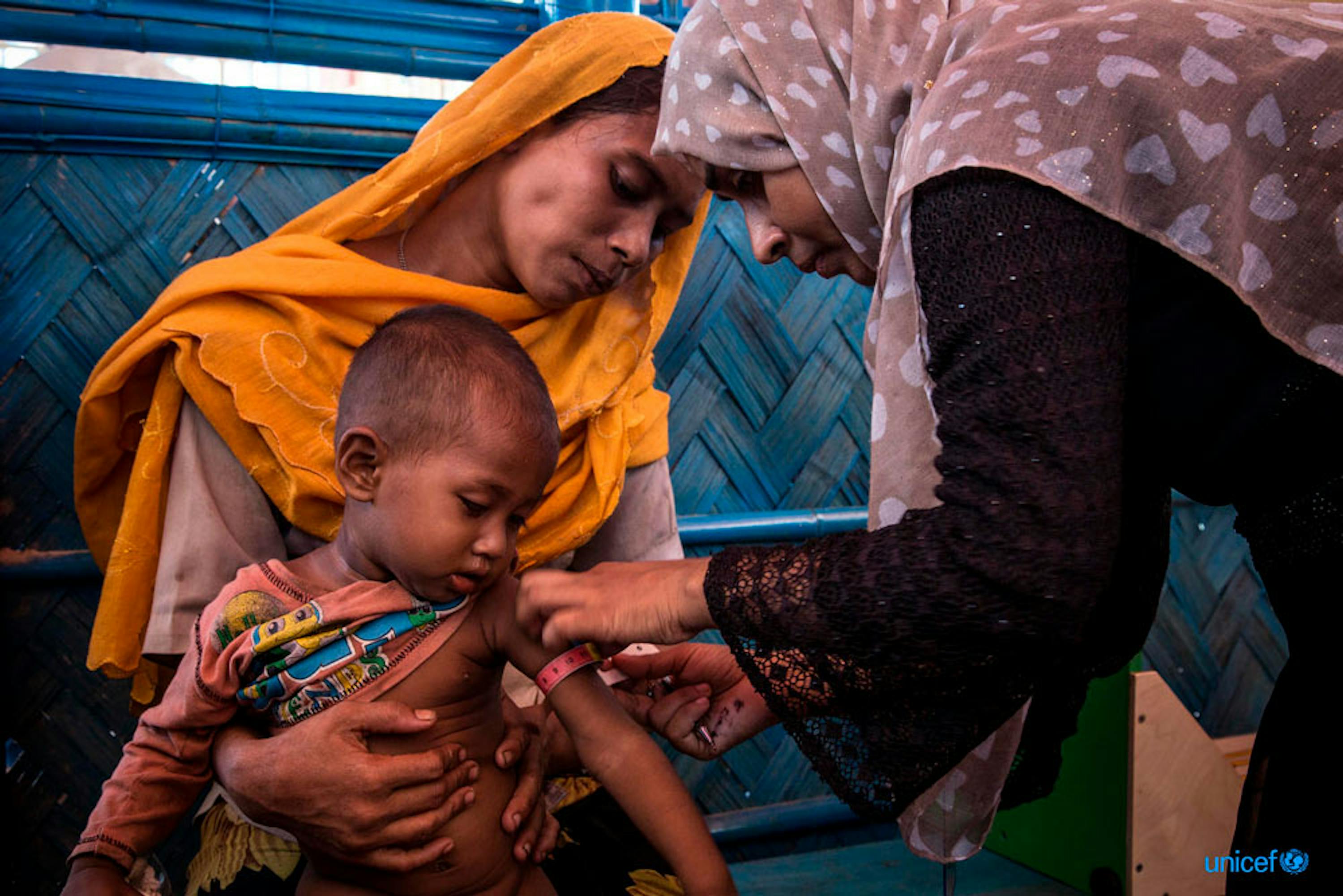 Un operatore sanitario locale  utilizza uno strumento atropometrico per determinare lo stato nutrizionale di questo bambino rohingya © UNICEF/UN0139599/LeMoyne